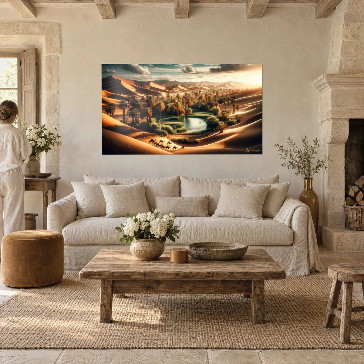 Tableau oasis cernée de dunes ocre, palmiers vert sombre et caravane de dromadaires, au-dessus d'un canapé dans un salon lumineux