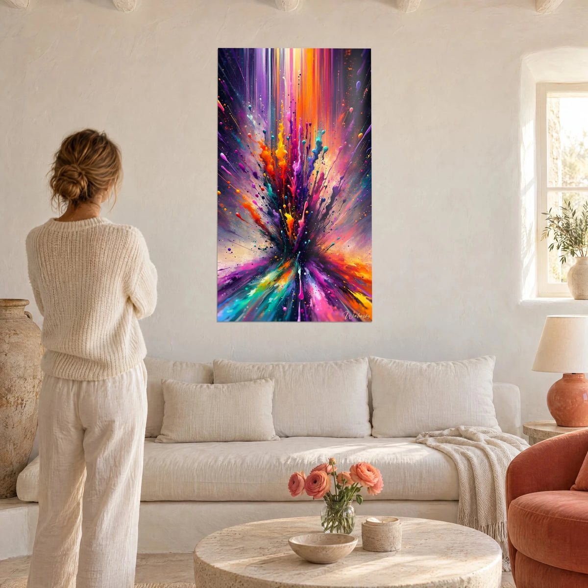 Wall art paint explosion in orange, violet and turquoise, splashes bursting from a black centre, above a sofa in a bright living room