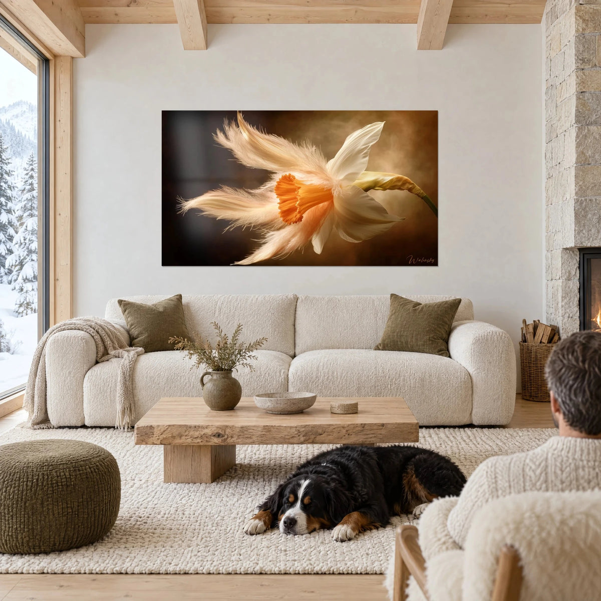 Tableau narcisse blanc aux pétales de plumes et trompe orange sur fond brun doré, au-dessus d'un canapé dans un salon lumineux