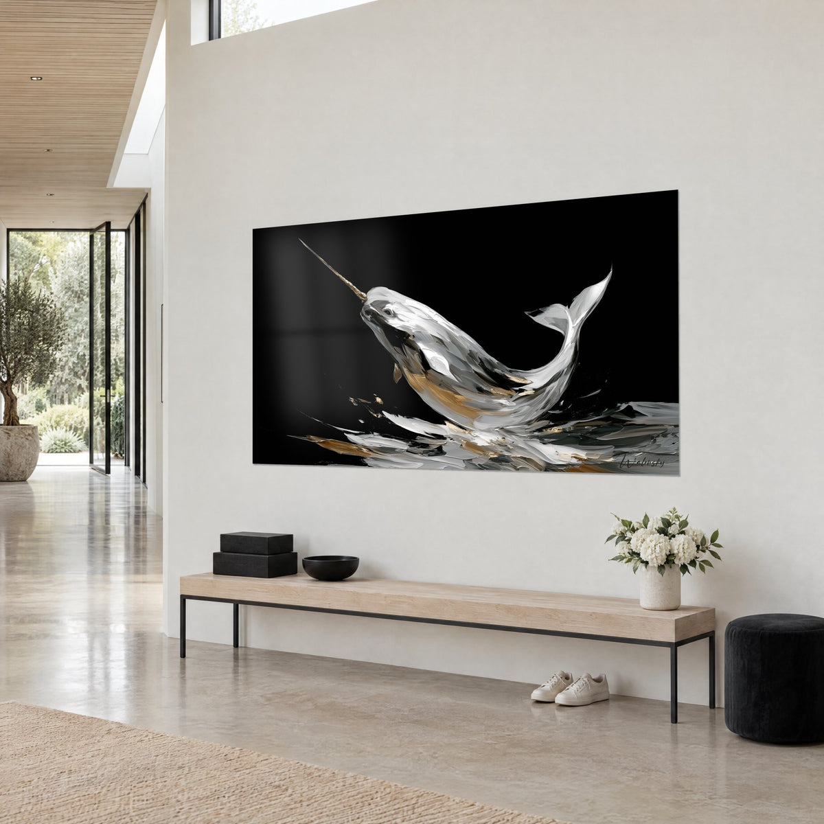 Wall art of a horned cetacean with a golden tusk leaping from silver water, deep black background, white tail raised, light wall of an architect's house