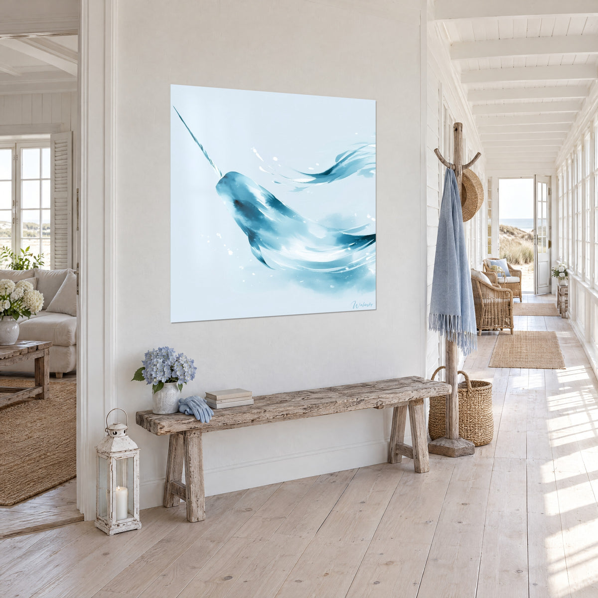Wall art whale with spiral tusk in glacier blue and white wash, splashes of foam, three-quarter view at the end of a sunlit hallway