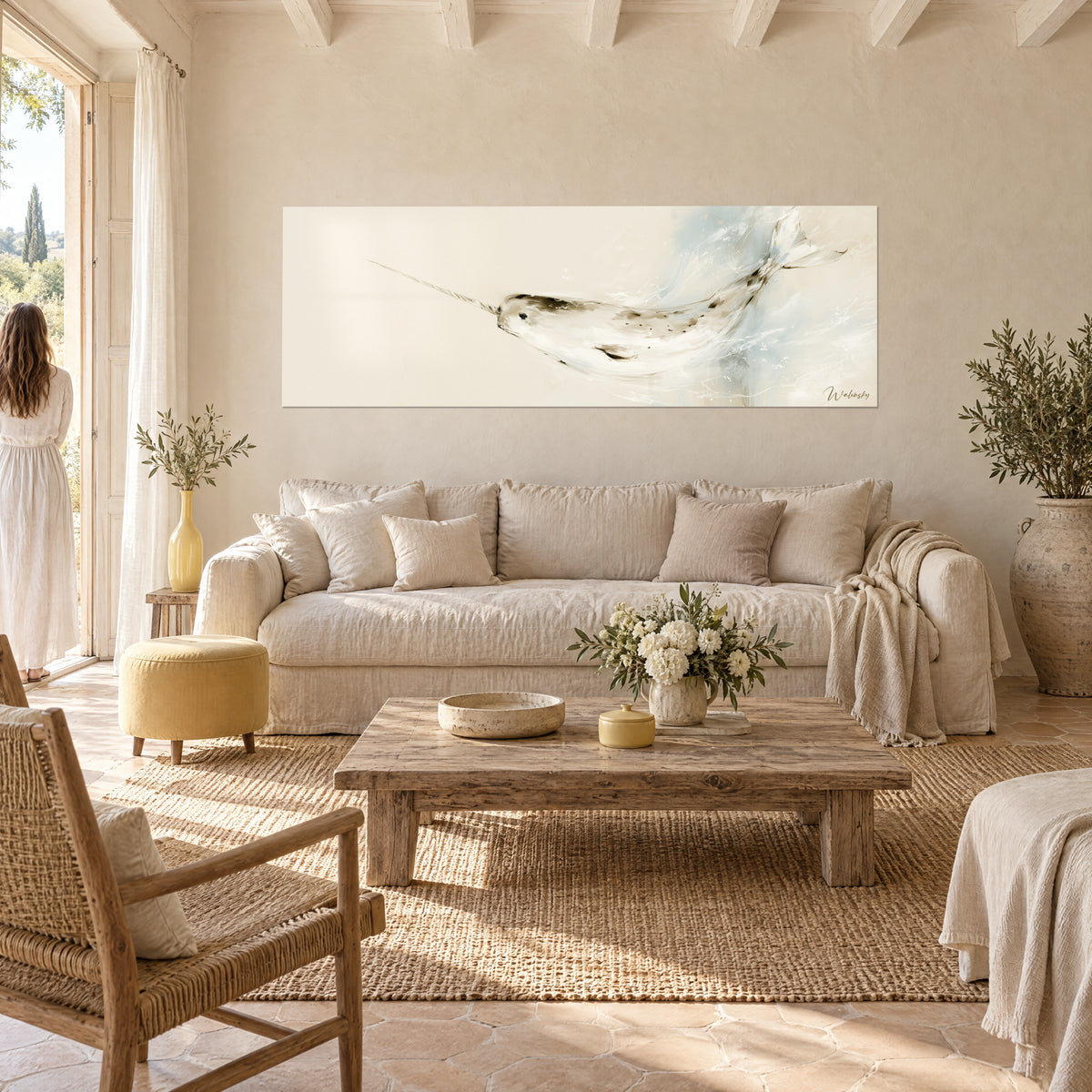 Gemälde Narwal weiß, nach links schwimmend, beige spiralförmiger Stoßzahn, hellblaue Spritzer, über einem Sofa in einem hellen Wohnzimmer