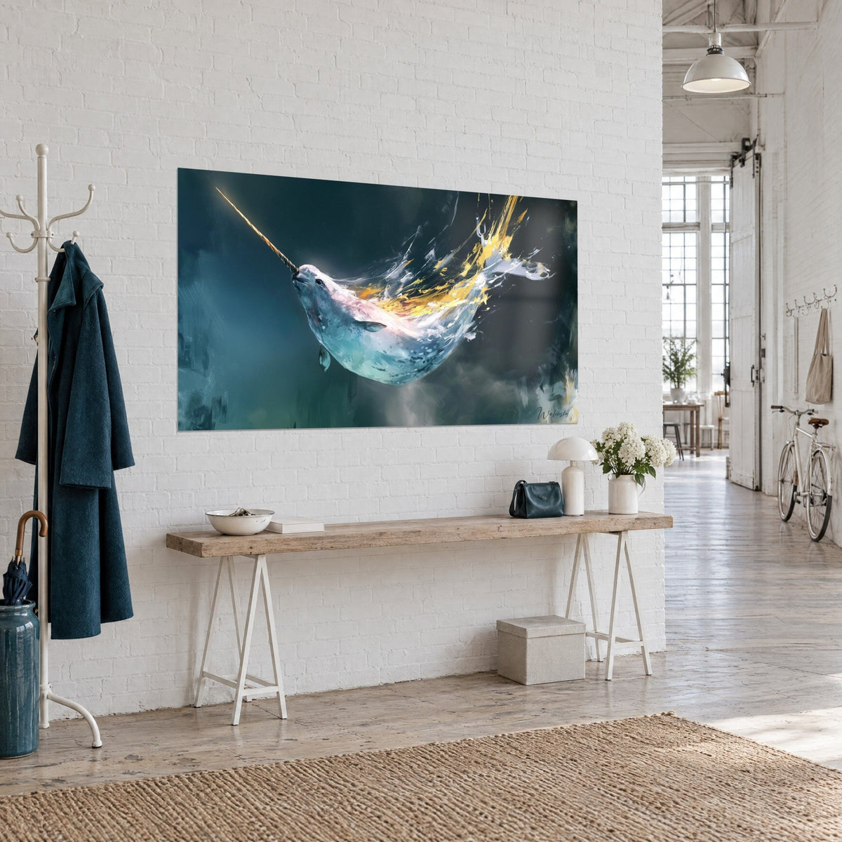 Wall art arctic whale with a long twisted horn, white back and a trail of melted gold, hung on a white brick wall in a loft