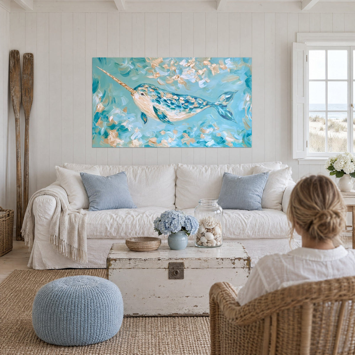 Wall art turquoise narwhal with a golden tusk, swimming through ivory brushstrokes, above a sofa in a bright living room