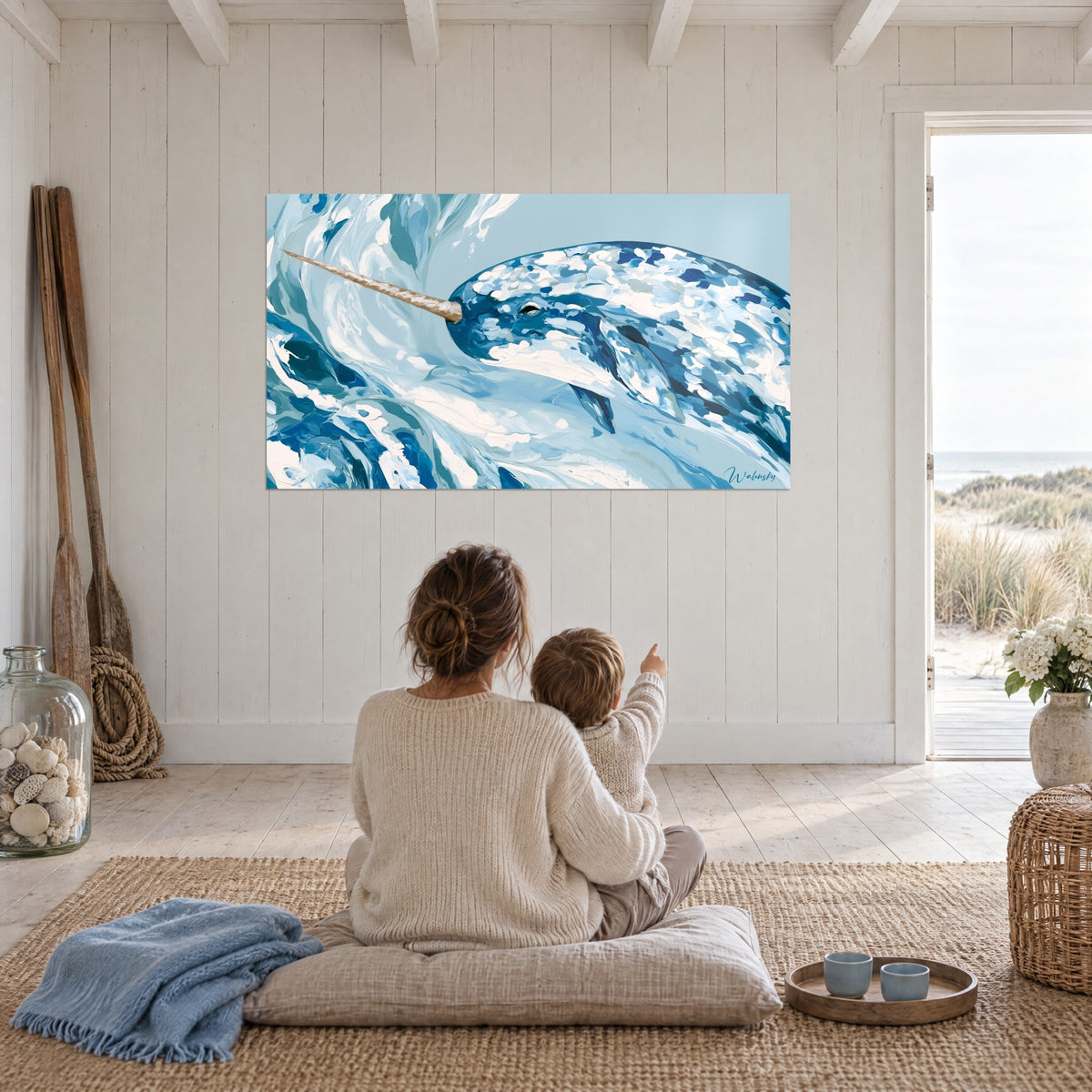 Cuadro ballena con colmillo que surge de la espuma azul vaquero y blanca, fondo azul pálido, frente a una madre y su hijo, casa junto al mar