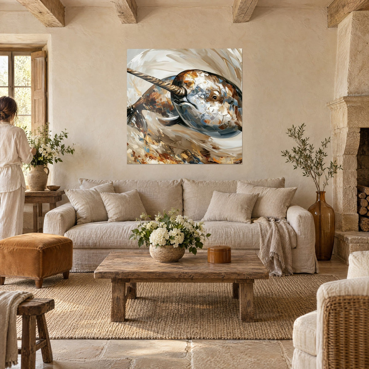 Wall art narwhal in ivory with a twisted tusk, blue and ochre palette-knife strokes, two people seen from behind above a sofa in a bright living room