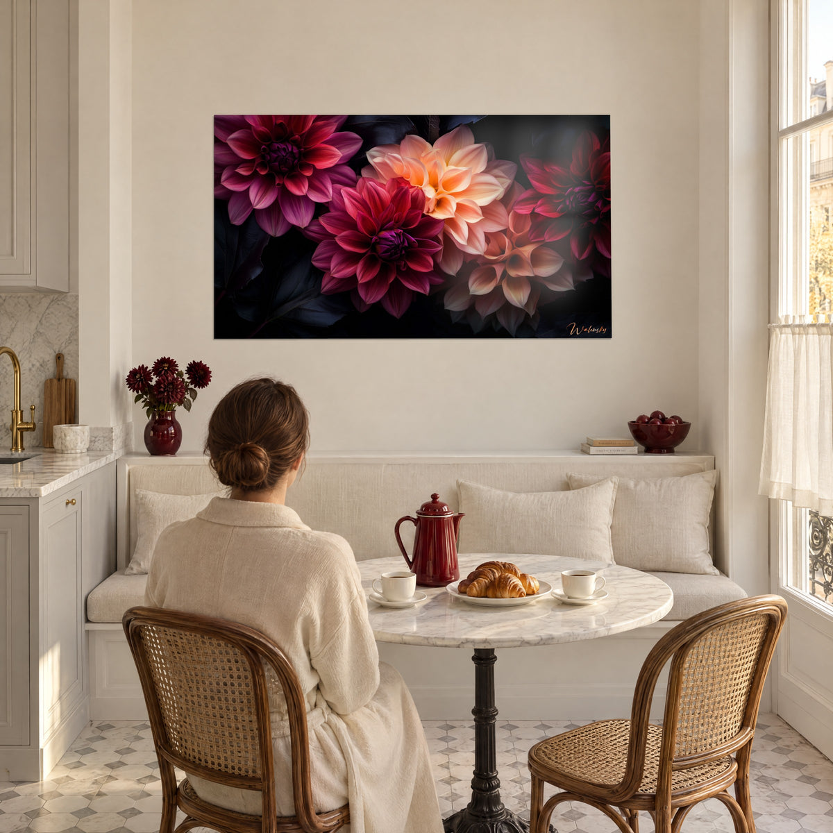 Cuadro de flores de dalia rojo vivo y naranja pálido, mujer de espaldas frente a un café y un cruasán, banco de una cocina blanca