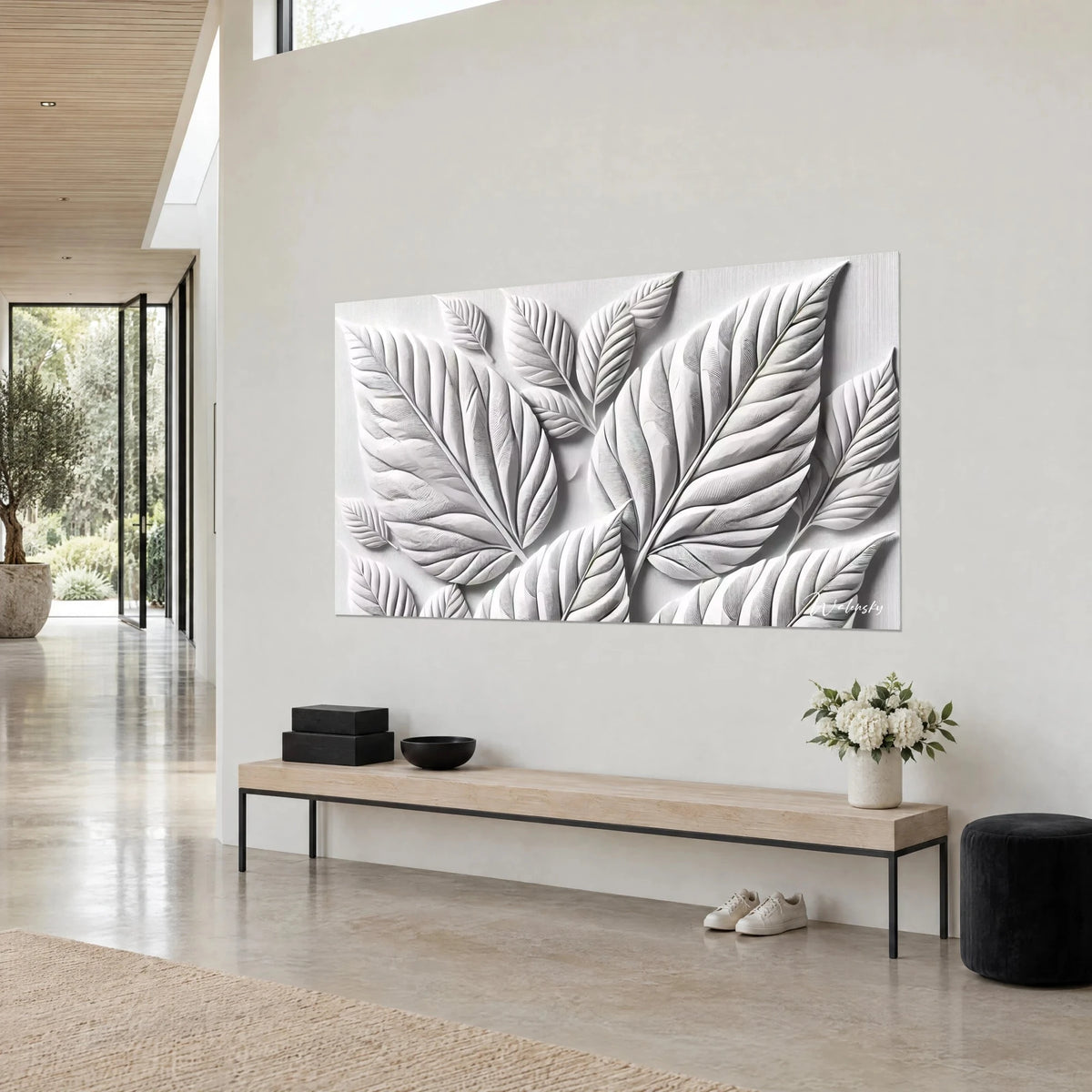 Tableau frondaisons de plâtre en relief, ivoire et gris argenté, grandes nervures obliques, sur un mur clair, vue de trois-quarts
