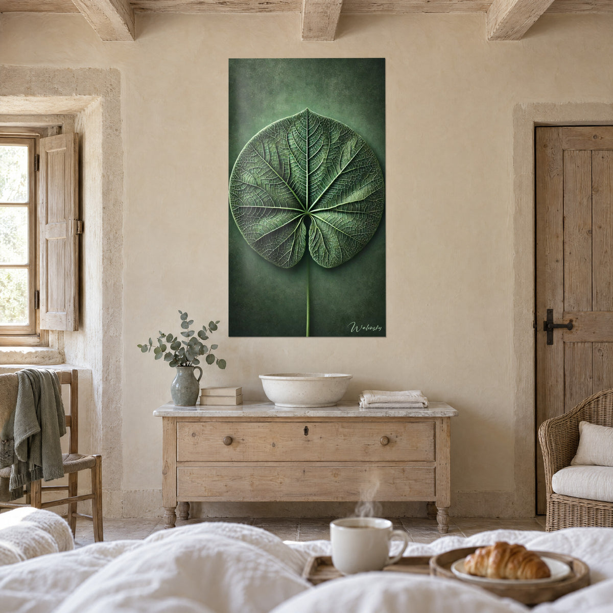 Cuadro de un limbo de hoja verde profundo surcado de venas claras, verde oliva y esmeralda, sobre una cama en un dormitorio luminoso