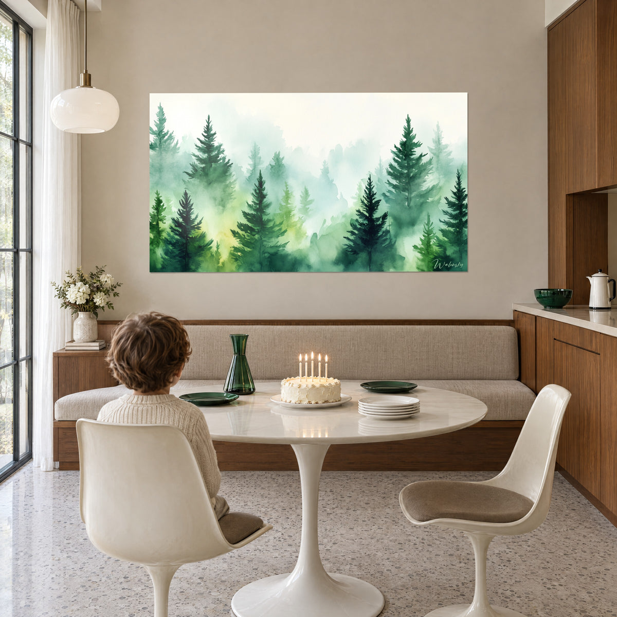 Wall art conifers rising from the fog, dark green and mint green, a child seen from behind at a round white table, birthday