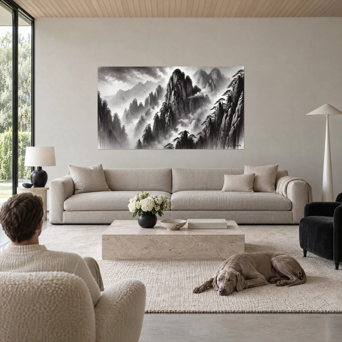 Quadro picchi rocciosi in bianco e nero immersi nella nebbia, pini scuri, un Weimaraner grigio sdraiato su un divano in un soggiorno luminoso