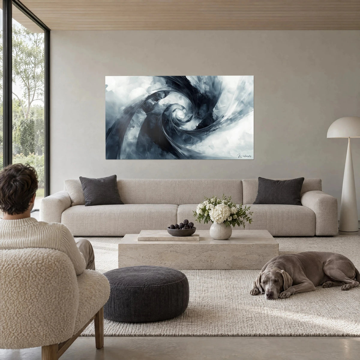 Quadro con spirale astratta nelle sfumature grigio-azzurro e nero, nucleo bianco luminoso, osservato da due persone sopra un divano in un soggiorno luminoso