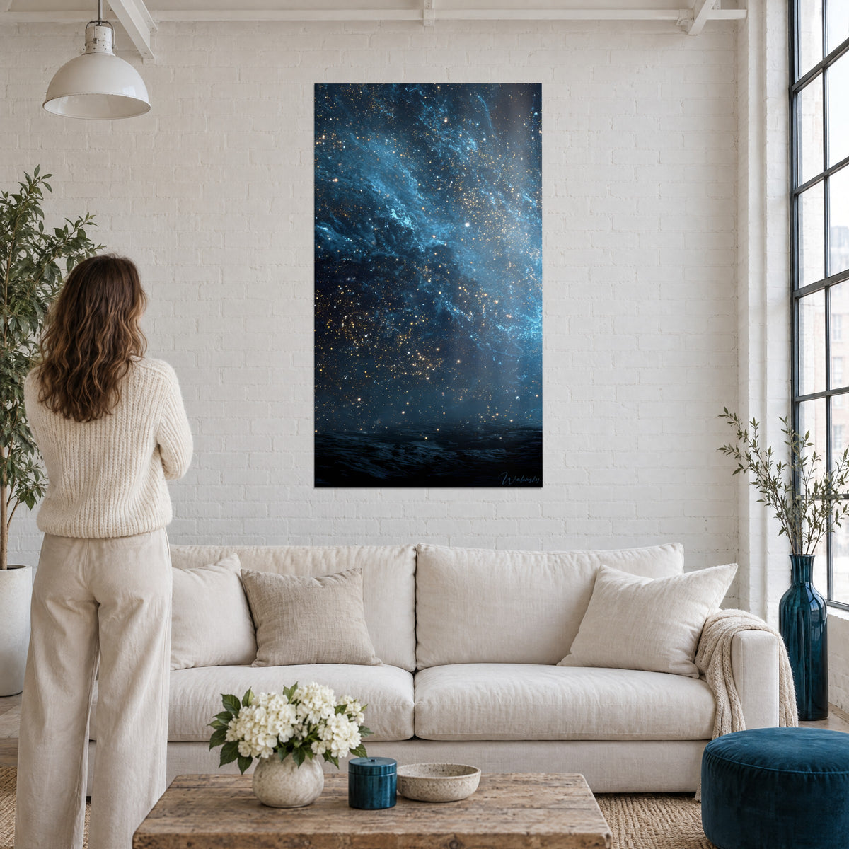 Gemälde Kosmischer Nebel in Mitternachtsblau mit goldenen Sternen, Frau von hinten, über einem Sofa in einem hellen Wohnzimmer