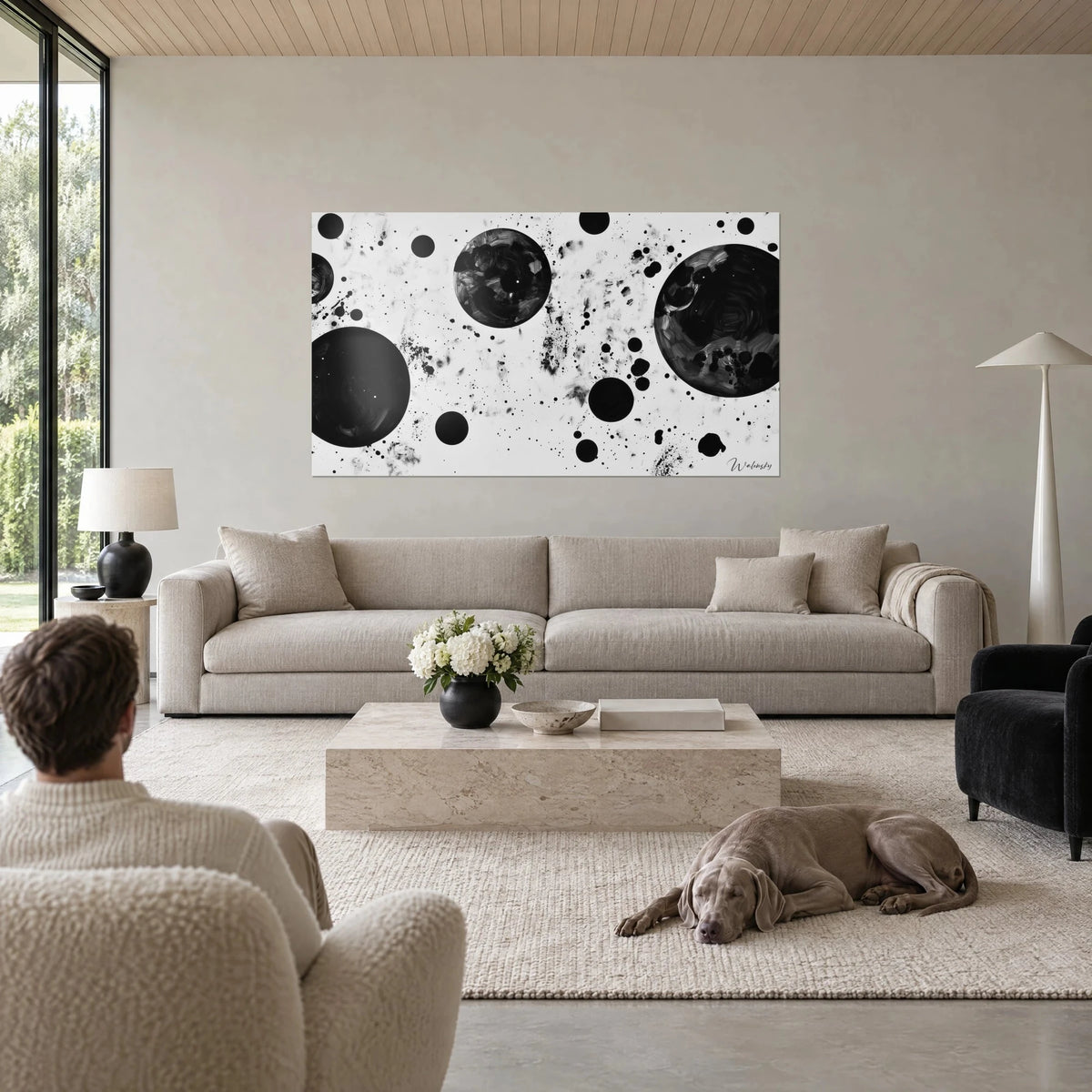 Quadro nebulosa in bianco e nero, sfere d'inchiostro scure e schizzi grigi sopra un divano in un soggiorno luminoso
