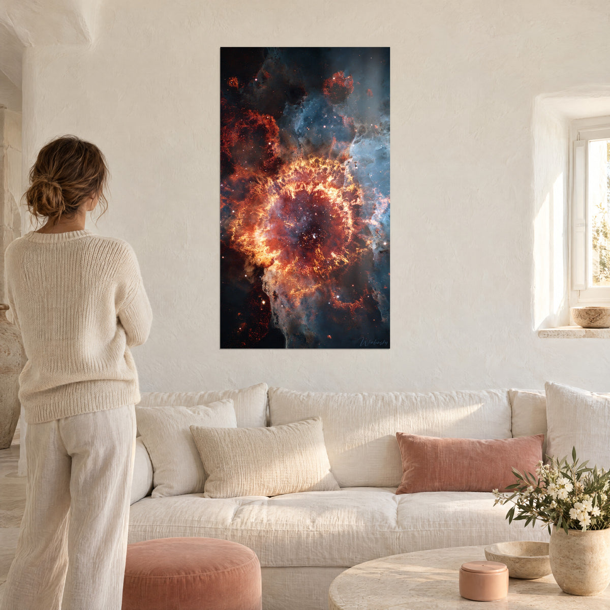 Tableau nébuleuse en explosion de braises orange et bleu glacier, femme de dos, au-dessus d'un canapé dans un salon lumineux
