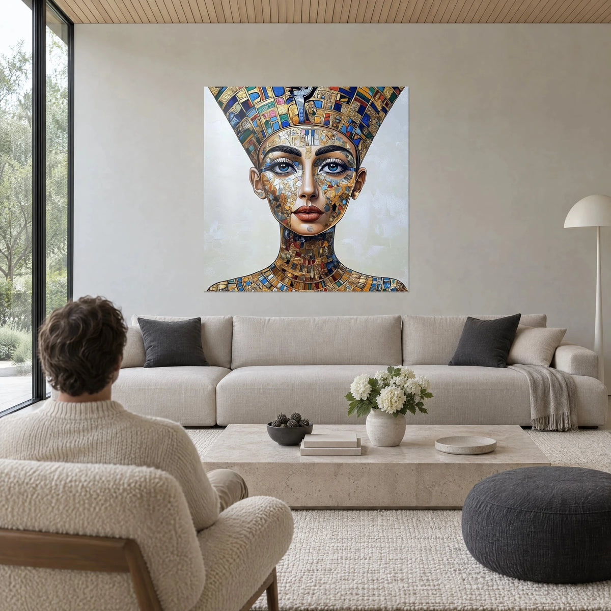 Cuadro reina egipcia con alto tocado de mosaico dorado y azul, ojos turquesa, encima de un sofá en un salón luminoso