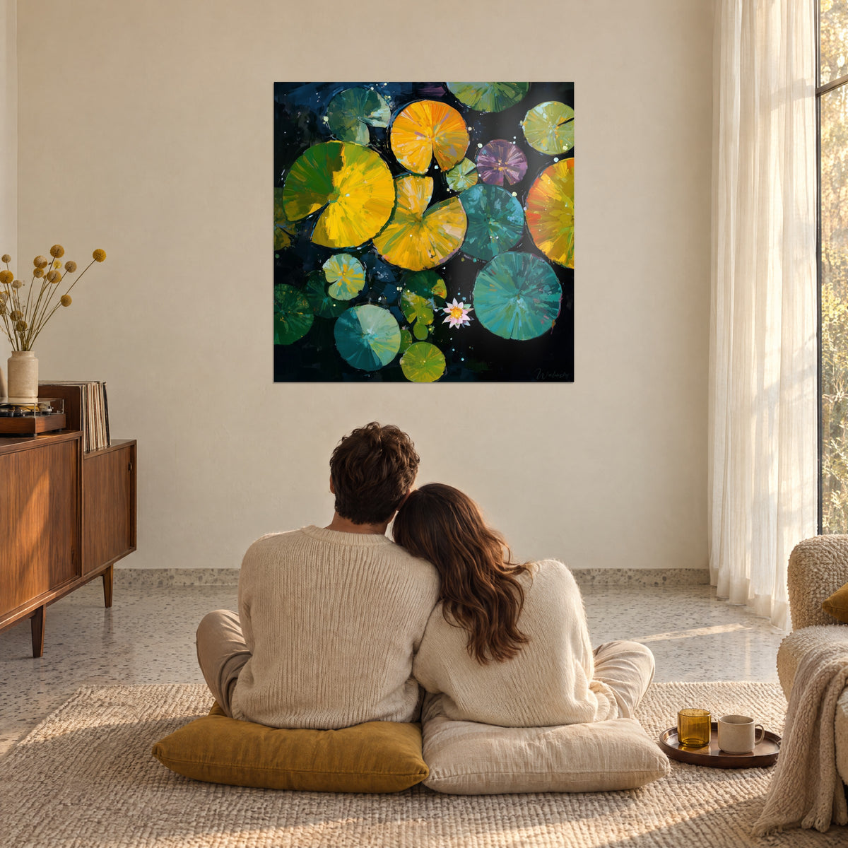 Schilderij van veelkleurige waterlelies op een donkere achtergrond, omhelsd koppel van achteren, mosterdgele kussens, in een zonovergoten woonkamer