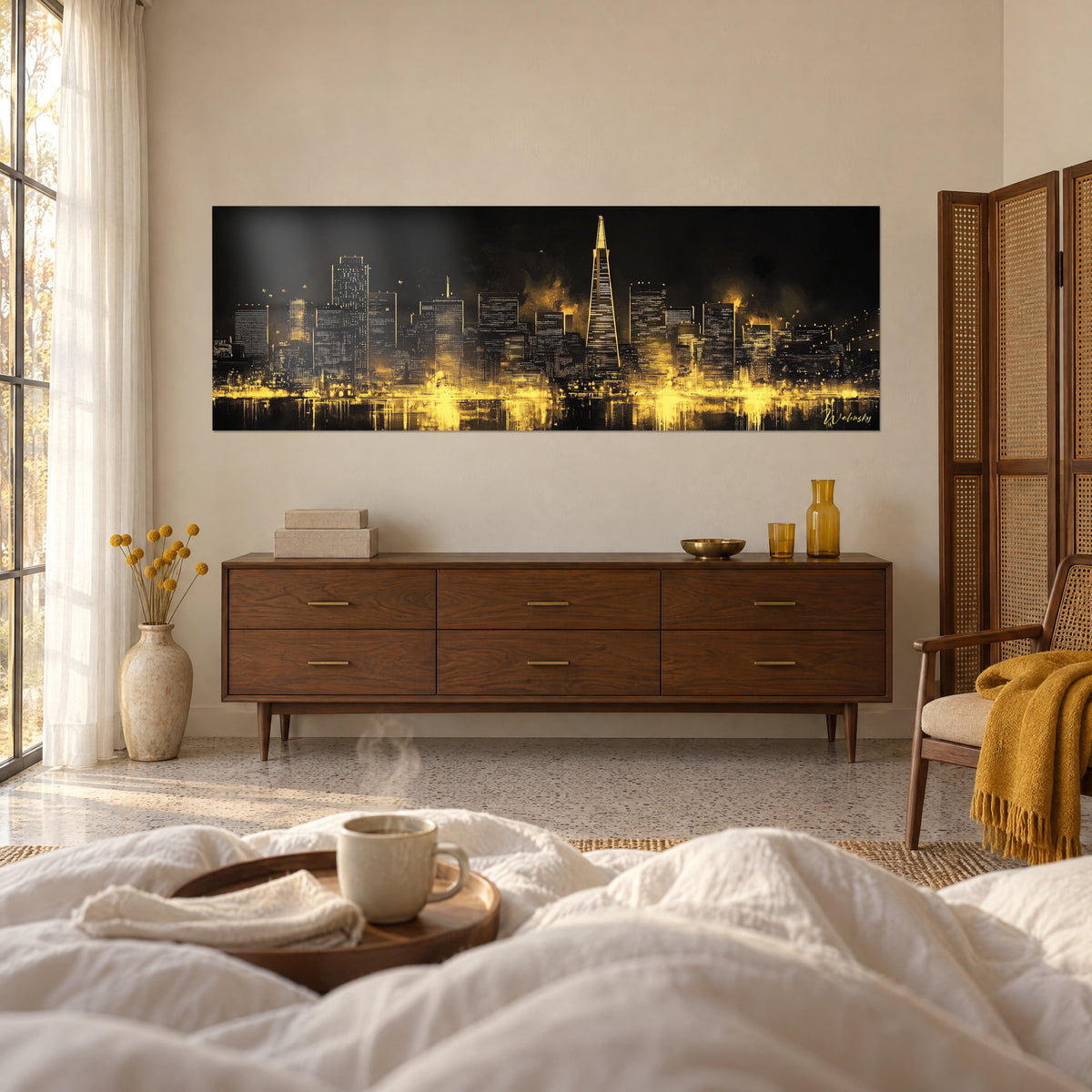 Cuadro silueta urbana ámbar sobre noche negra, punta piramidal iluminada, manta mostaza, sobre una cama en un dormitorio luminoso