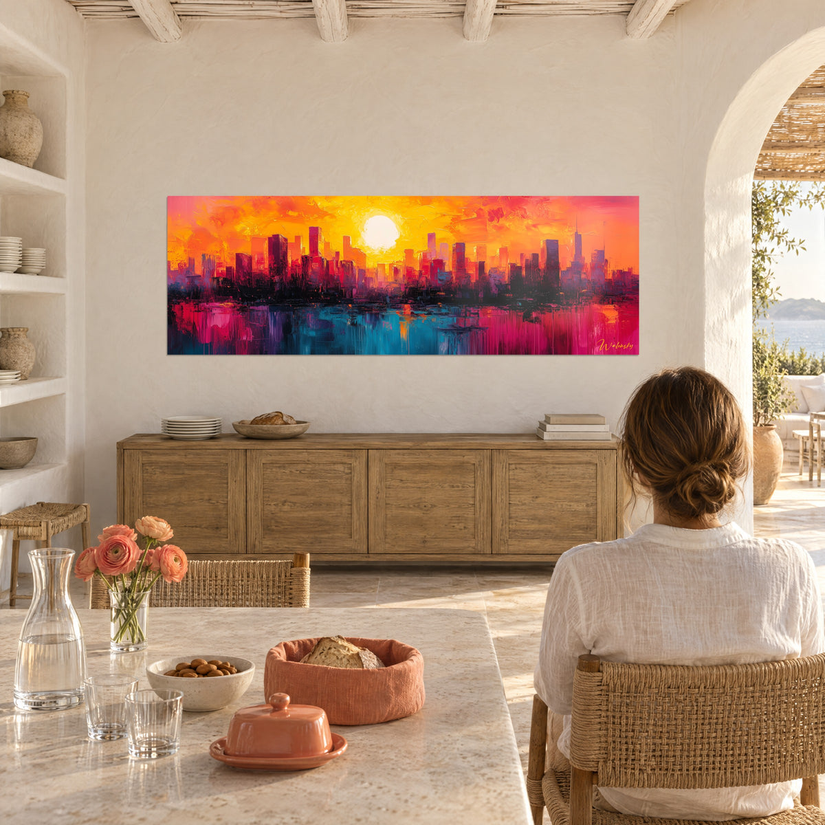 Cuadro de ciudad al crepúsculo, gran sol blanco en un cielo amarillo y naranja, torres oscuras, agua rosa y turquesa, frente a una mesa de comedor