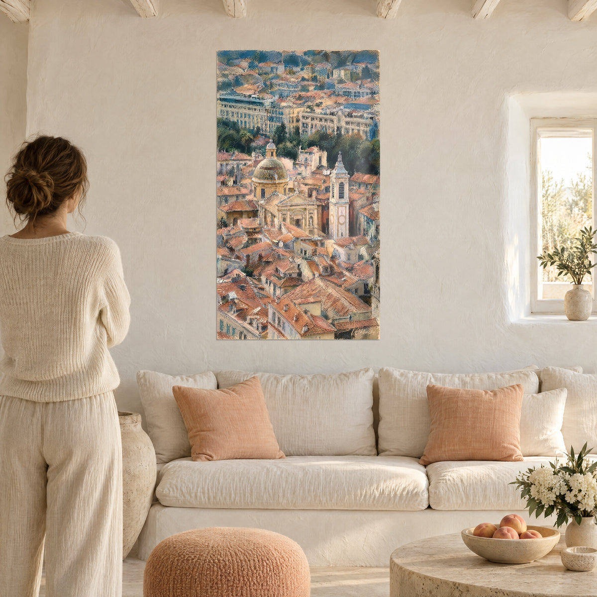 Schilderij kathedraal van Nice en zee van terracotta daken, groene koepel, vrouw van achteren, boven een bank in een lichte woonkamer