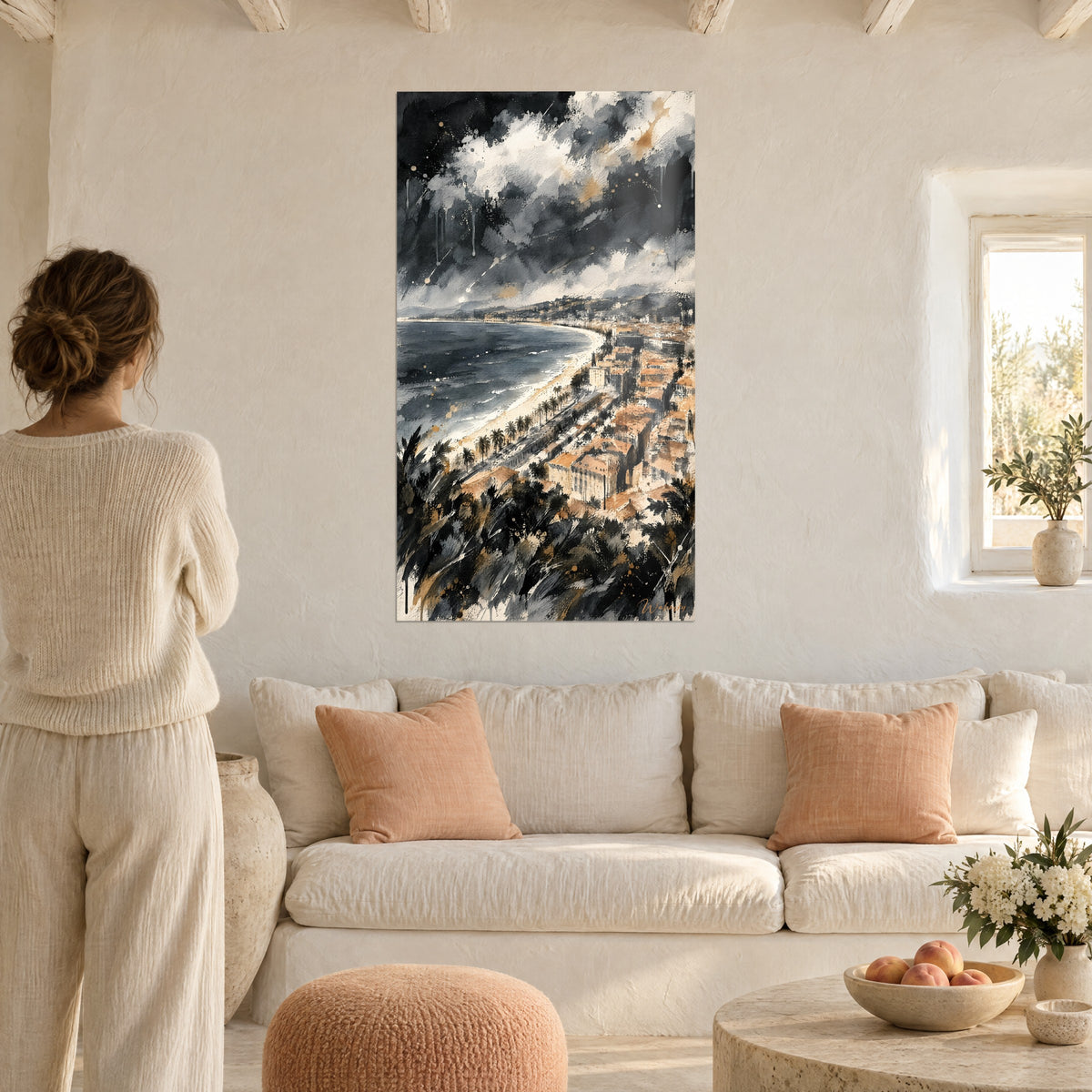 Quadro baia di Nizza sotto il temporale, acquerello antracite e ocra, donna di spalle, sopra un divano in un soggiorno luminoso