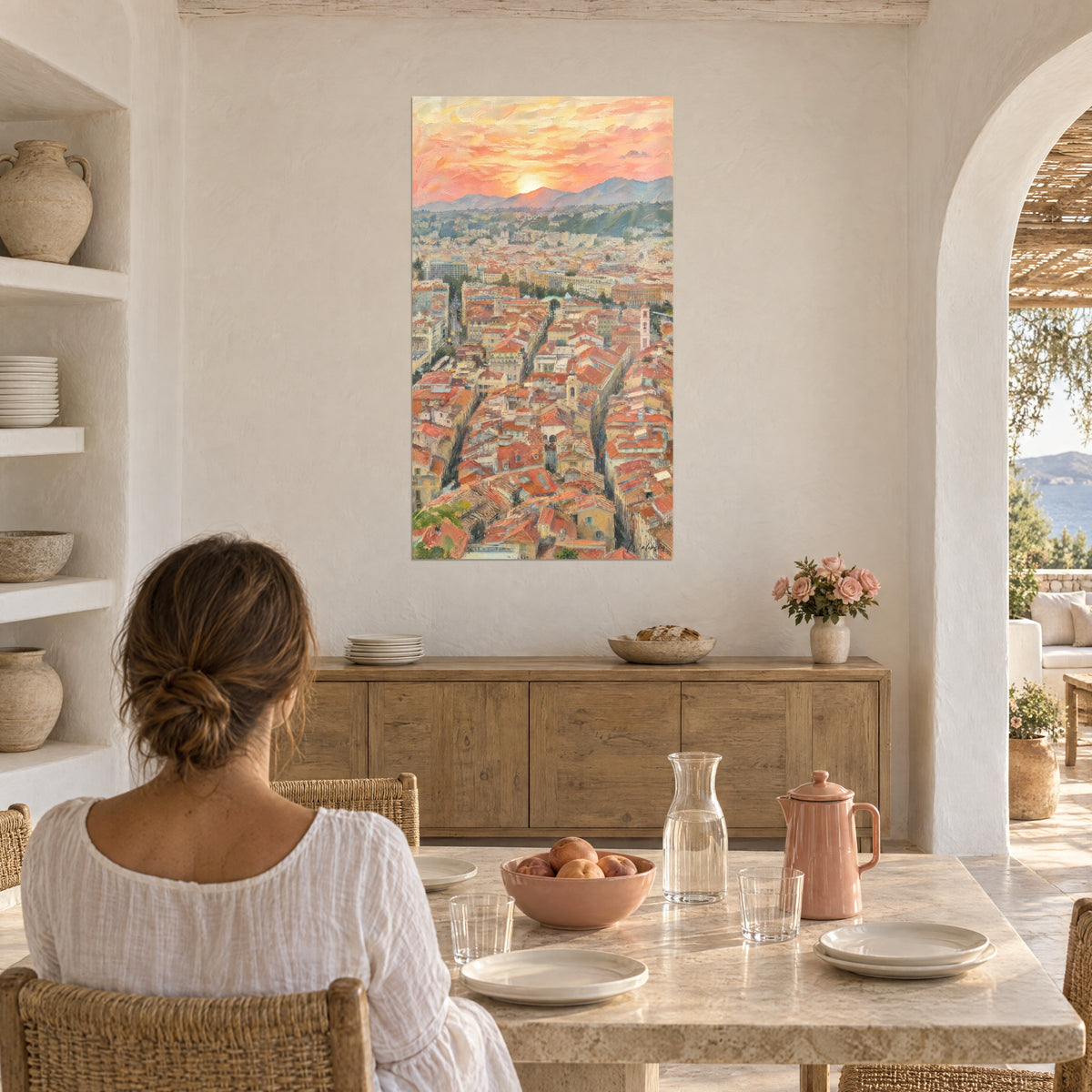 Schilderij ontspannen over een zee van terracotta daken, abrikooskleurige wolken en mauwe bergen, vrouw van achteren voor een bloemrijke marmeren tafel