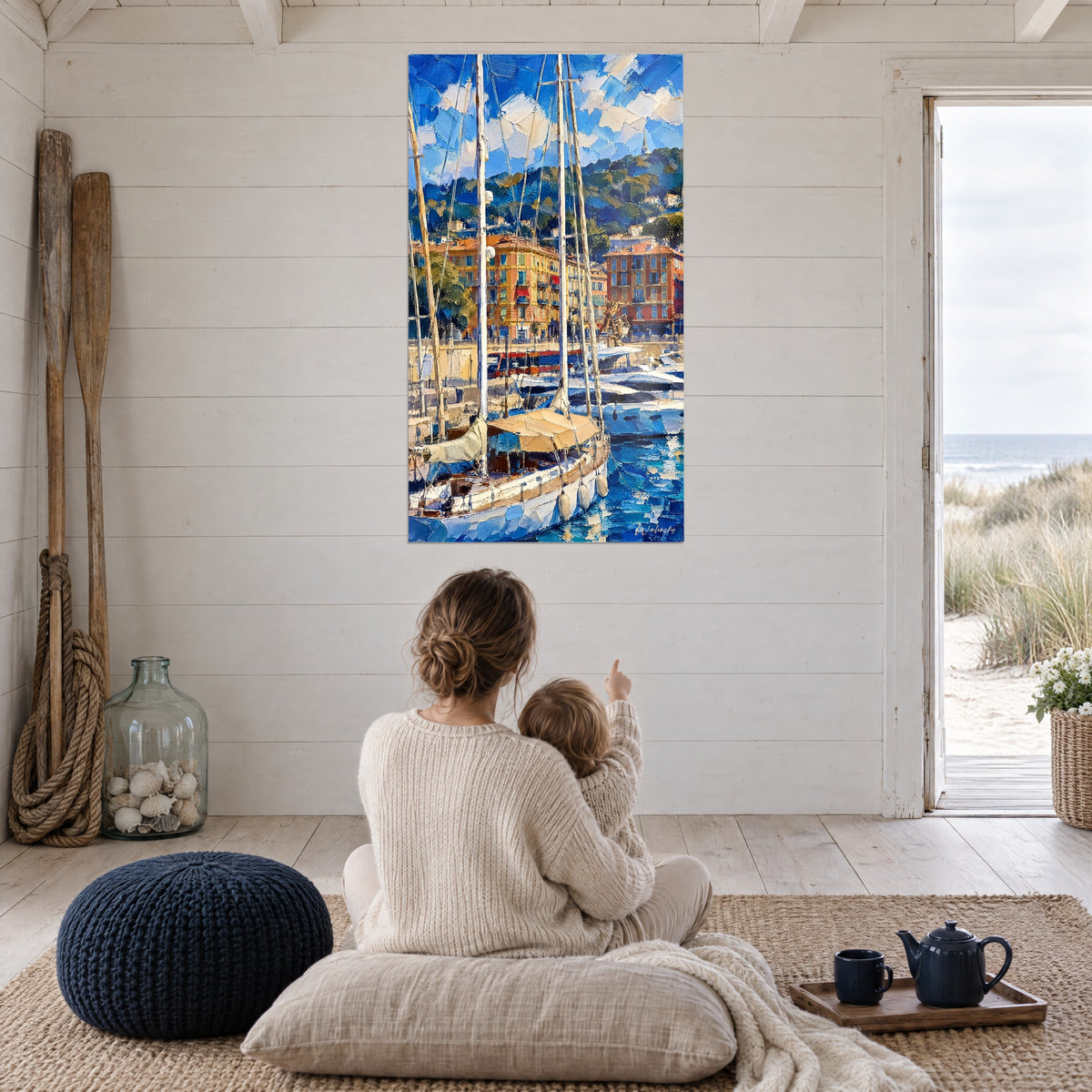 Schilderij jachthaven met beige opgerolde zeilen en diepblauwe weerspiegelingen, moeder en kind van achteren in een open woonkamer met uitzicht op het strand