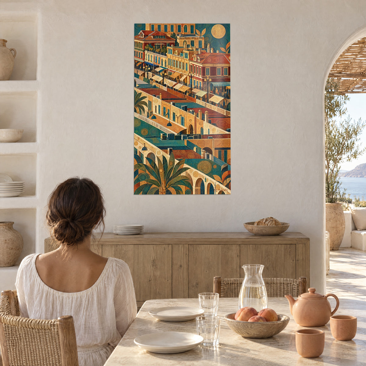 Quadro edifici mediterranei con lampioni in ferro battuto, giallo sabbia e blu anatra, donna di spalle seduta a un tavolo da pranzo