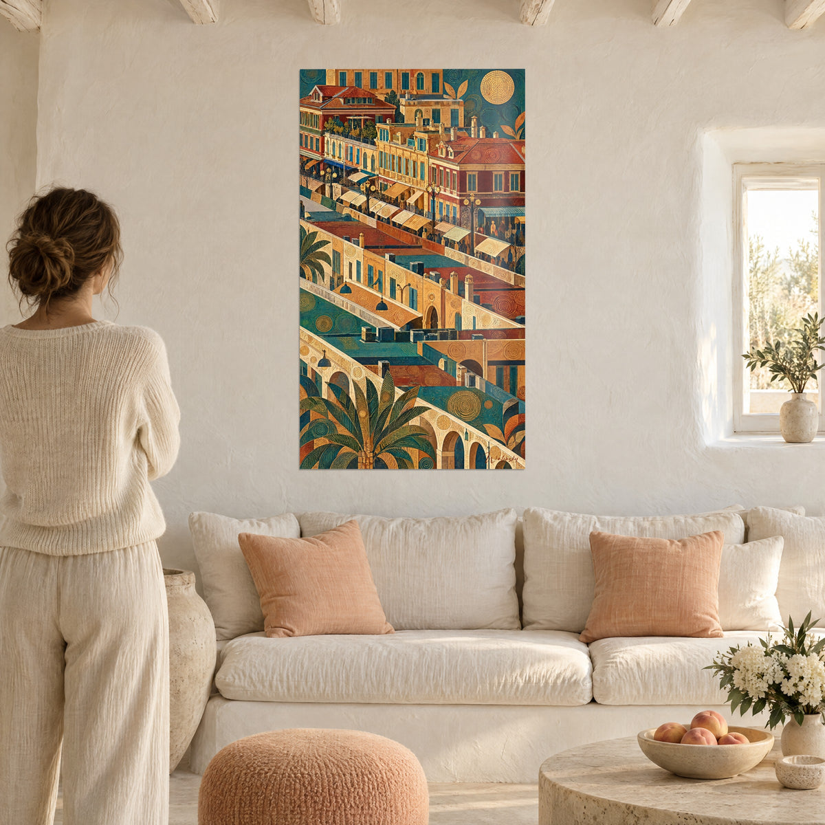 Quadro passeggiata stilizzata con tetti ocra e blu petrolio, palma verde, donna di spalle sopra un divano in un soggiorno luminoso