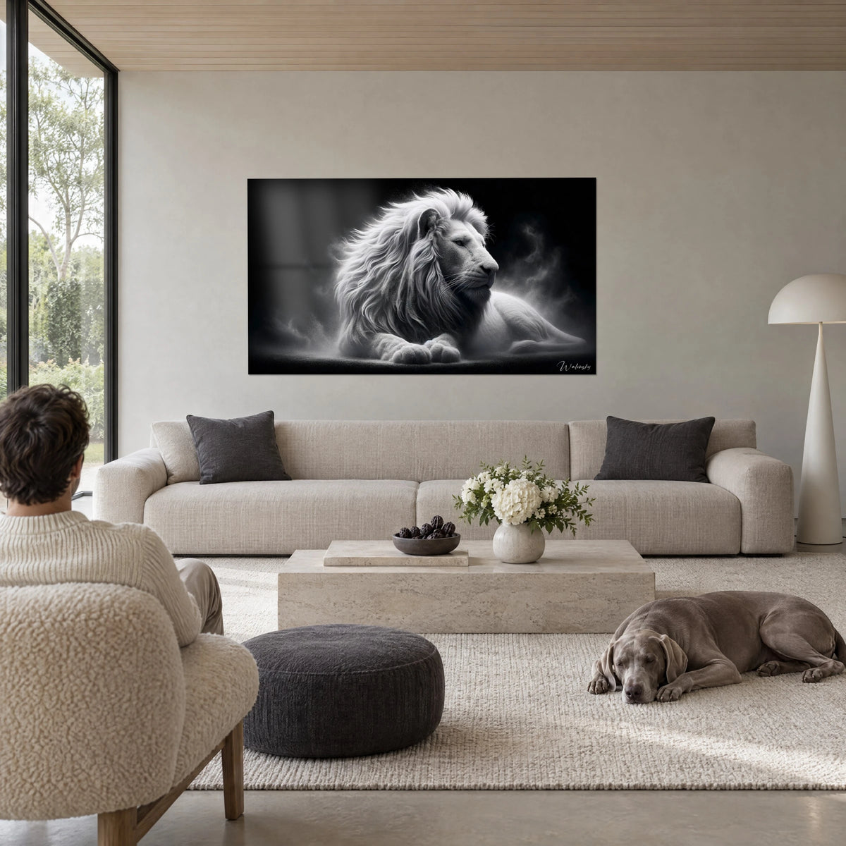 Cuadro león blanco tumbado, melena plateada sobre fondo negro, encima de un sofá en un salón luminoso