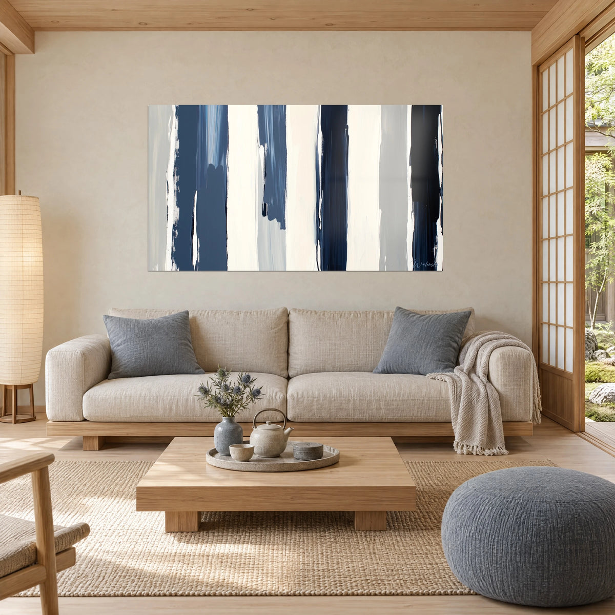 Wall art with navy and cream vertical stripes, grey accents, broad brushstroke, above a sofa in a bright living room