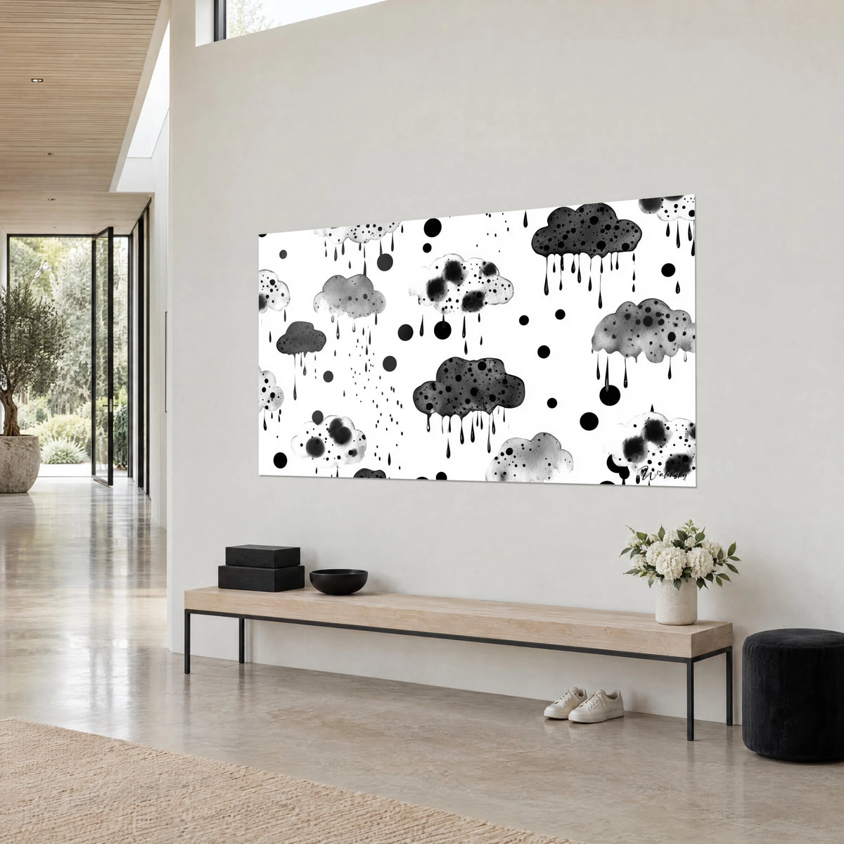 Cuadro de aguaceros de tinta en nubes grises moteadas, gotas negras sobre fondo blanco, visto en tres cuartos sobre un banco de madera clara