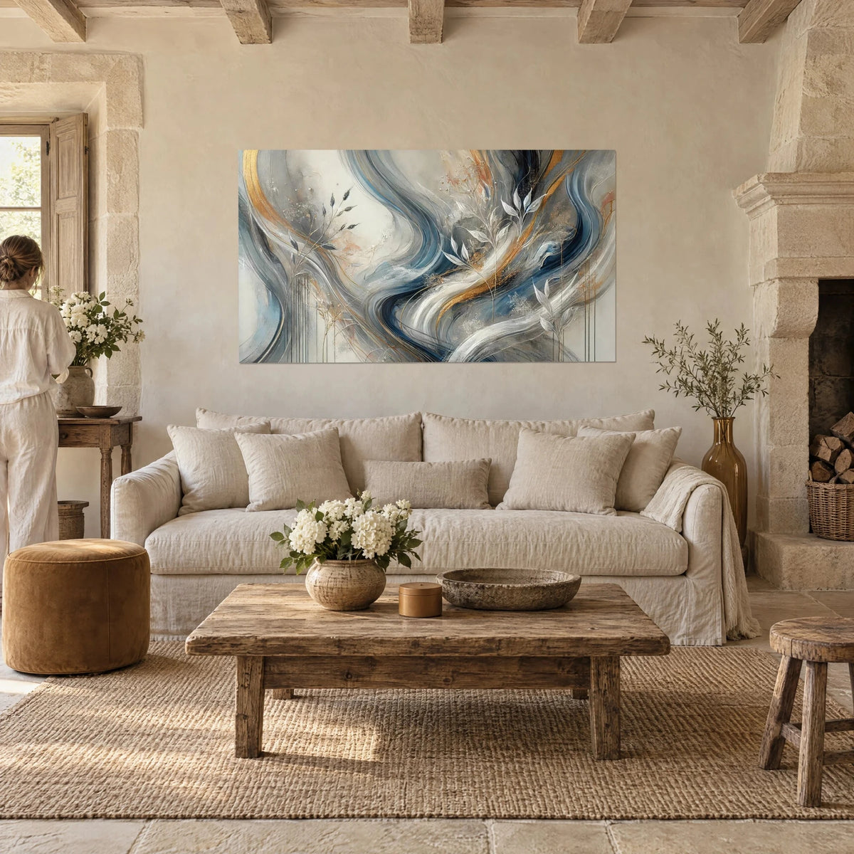 Quadro con volute fluide blu notte e oro, foglie argentate, donna di spalle, sopra un divano in un soggiorno luminoso