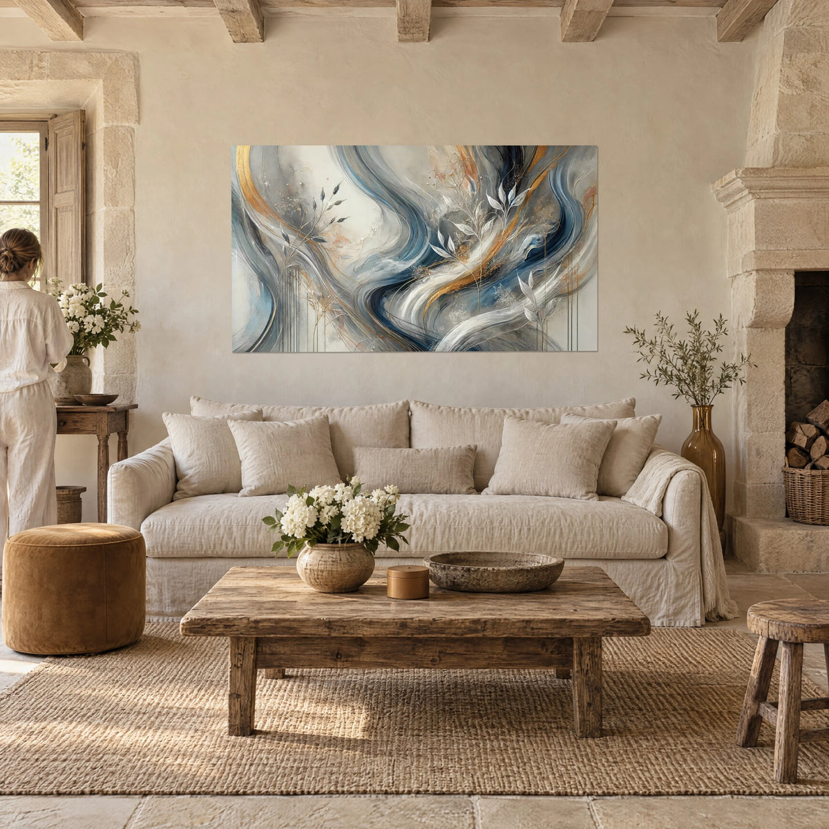Wall art with fluid swirls in midnight blue and gold, silver leaves, woman seen from behind, above a sofa in a bright living room