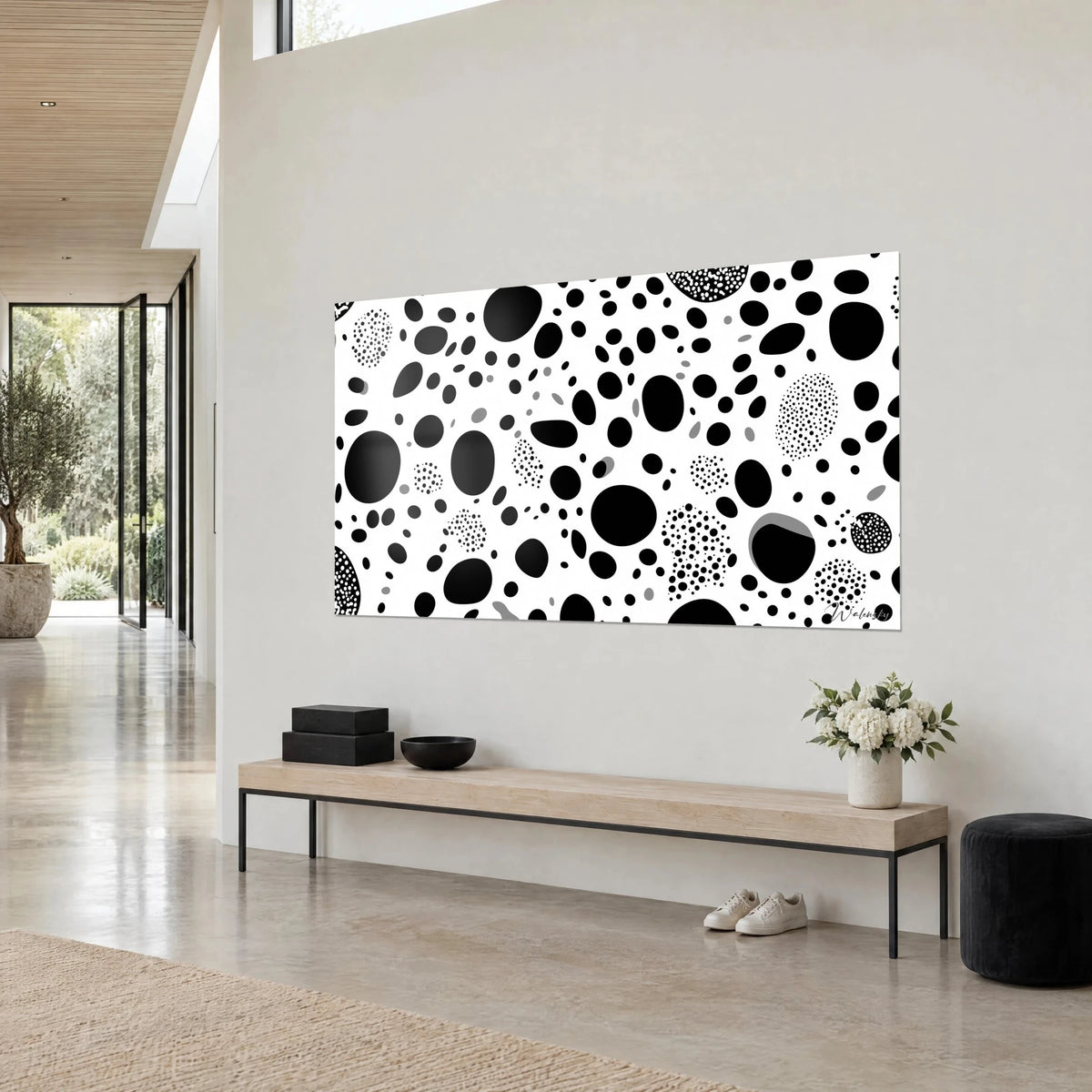 Tableau motif de galets noirs et amas de points sur blanc, ovales gris épars, au-dessus d'un banc en bois clair