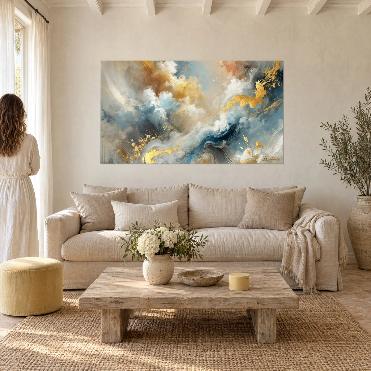 Tableau nuées abstraites d'or et de bleu pâle, volutes blanches et éclats dorés, au-dessus d'un canapé dans un salon lumineux