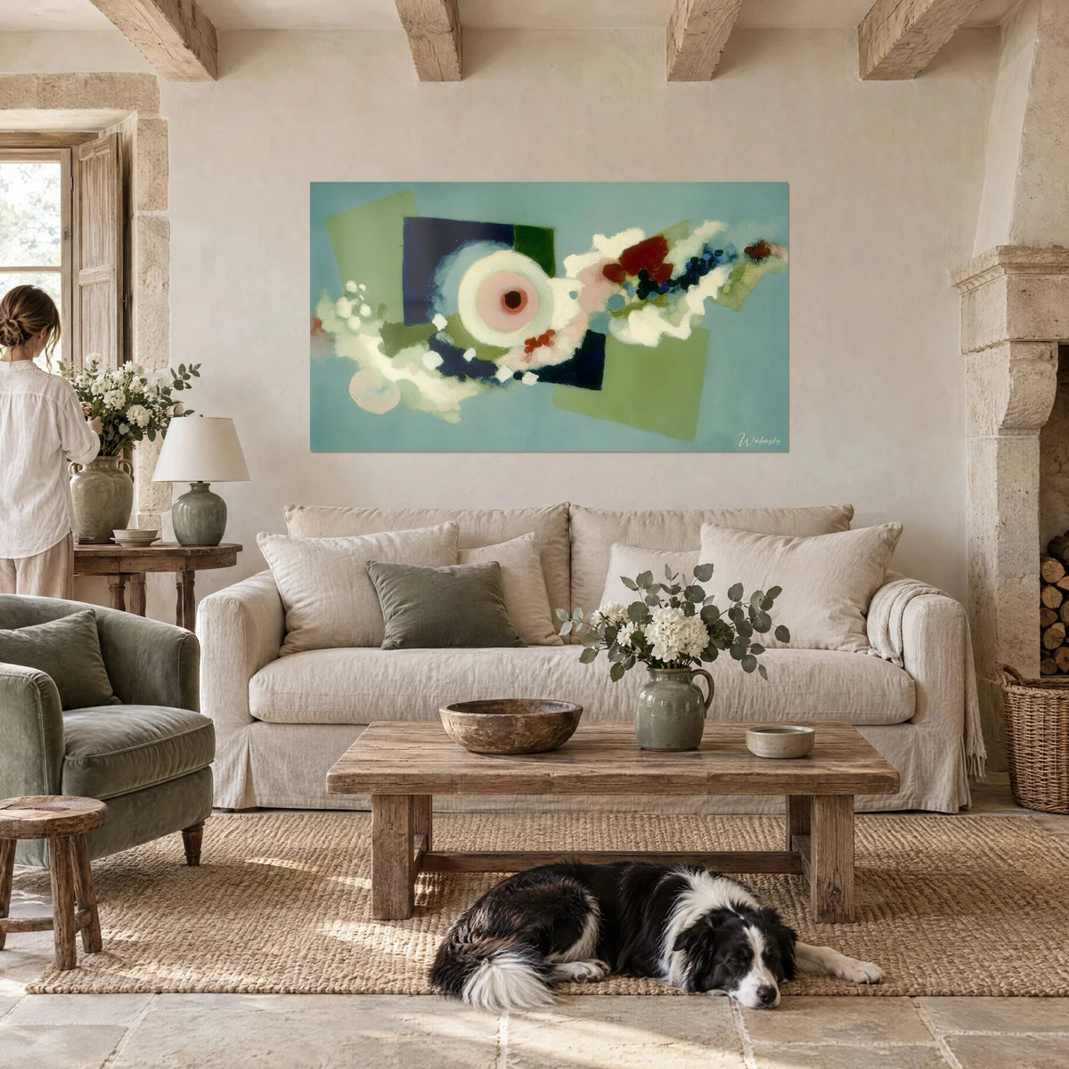Tableau œil rose cerclé de blanc crème, carrés bleu nuit et vert olive, au-dessus d'un canapé dans un salon lumineux