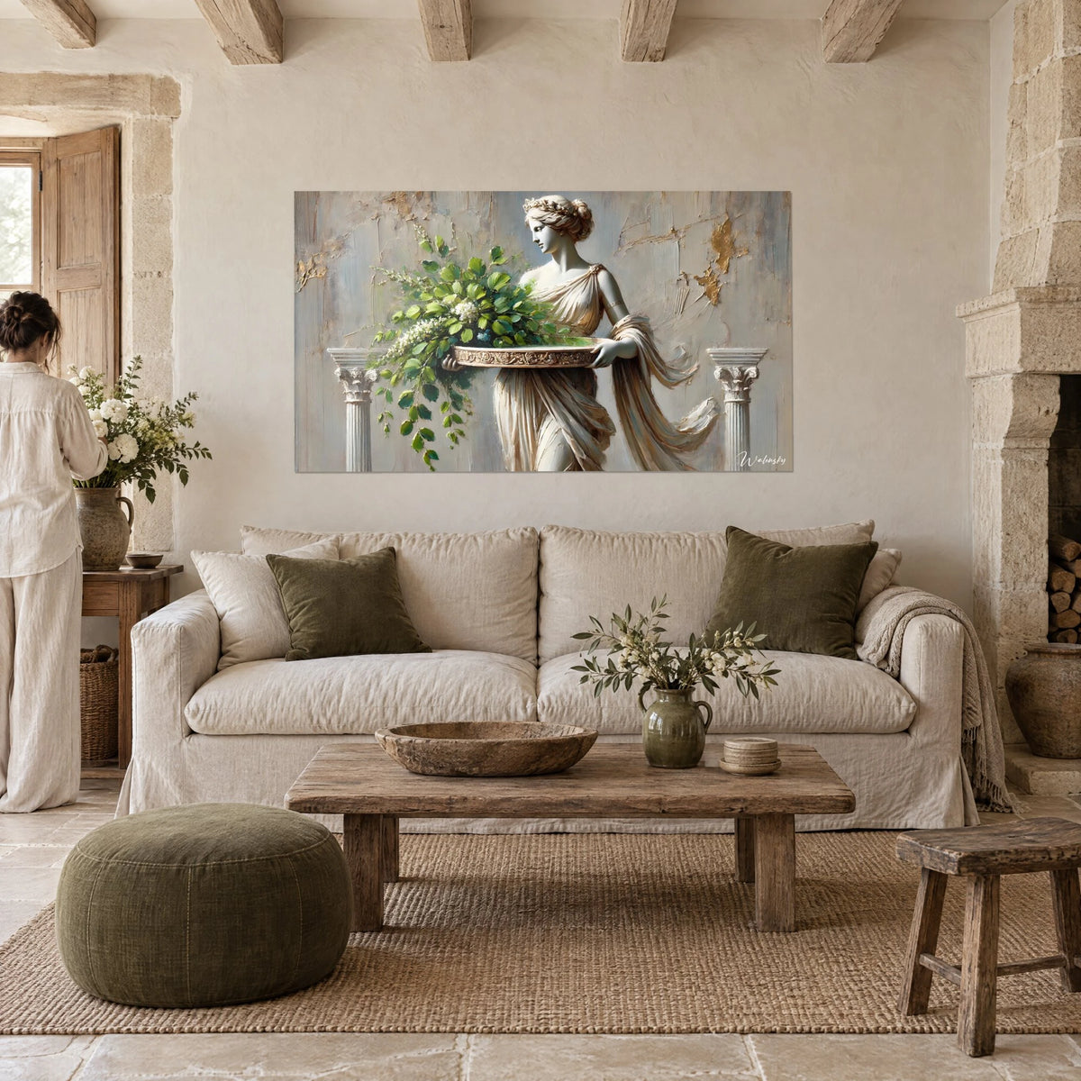 Quadro statua antica drappeggiata d'avorio che regge un vassoio di fogliame verde, sfondo grigio-azzurro, sopra un divano in un soggiorno luminoso
