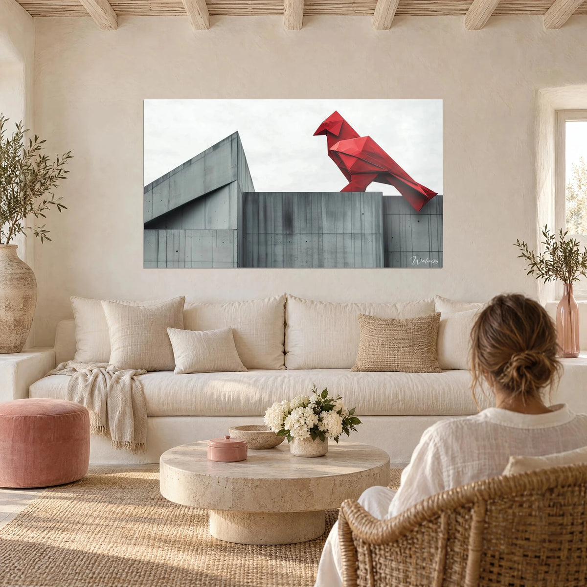 Tableau cardinal rouge en origami perché sur un mur de béton gris, ciel pâle, au-dessus d'un canapé dans un salon lumineux