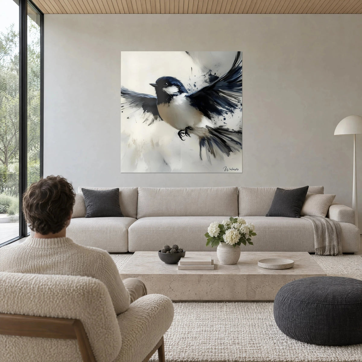 Quadro di rondine con le ali spiegate, piumaggio blu notte e petto color crema, sopra un divano in un soggiorno luminoso