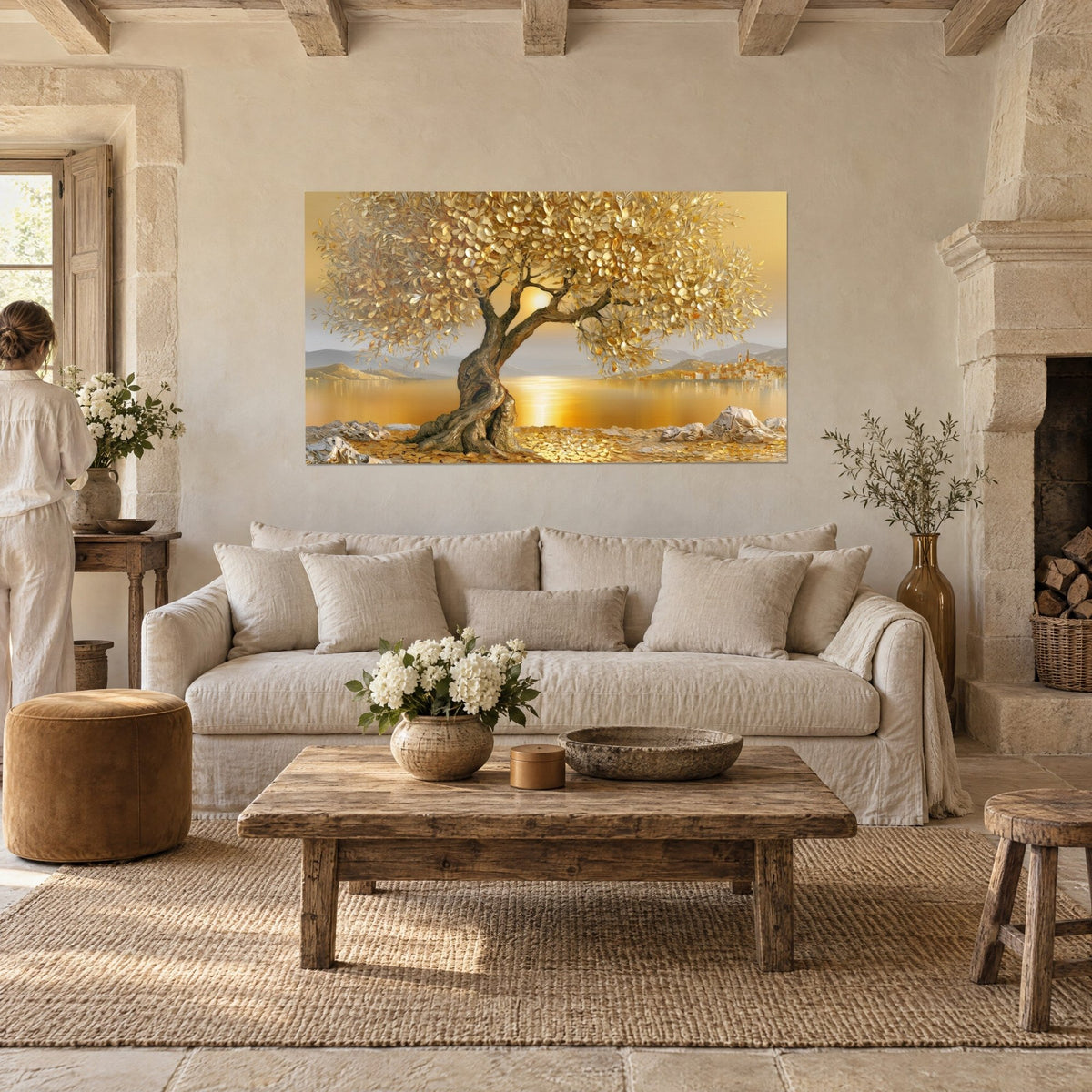 Wall art golden olive tree leaves over a lake at sunset, a woman seen from behind above a sofa in a bright living room