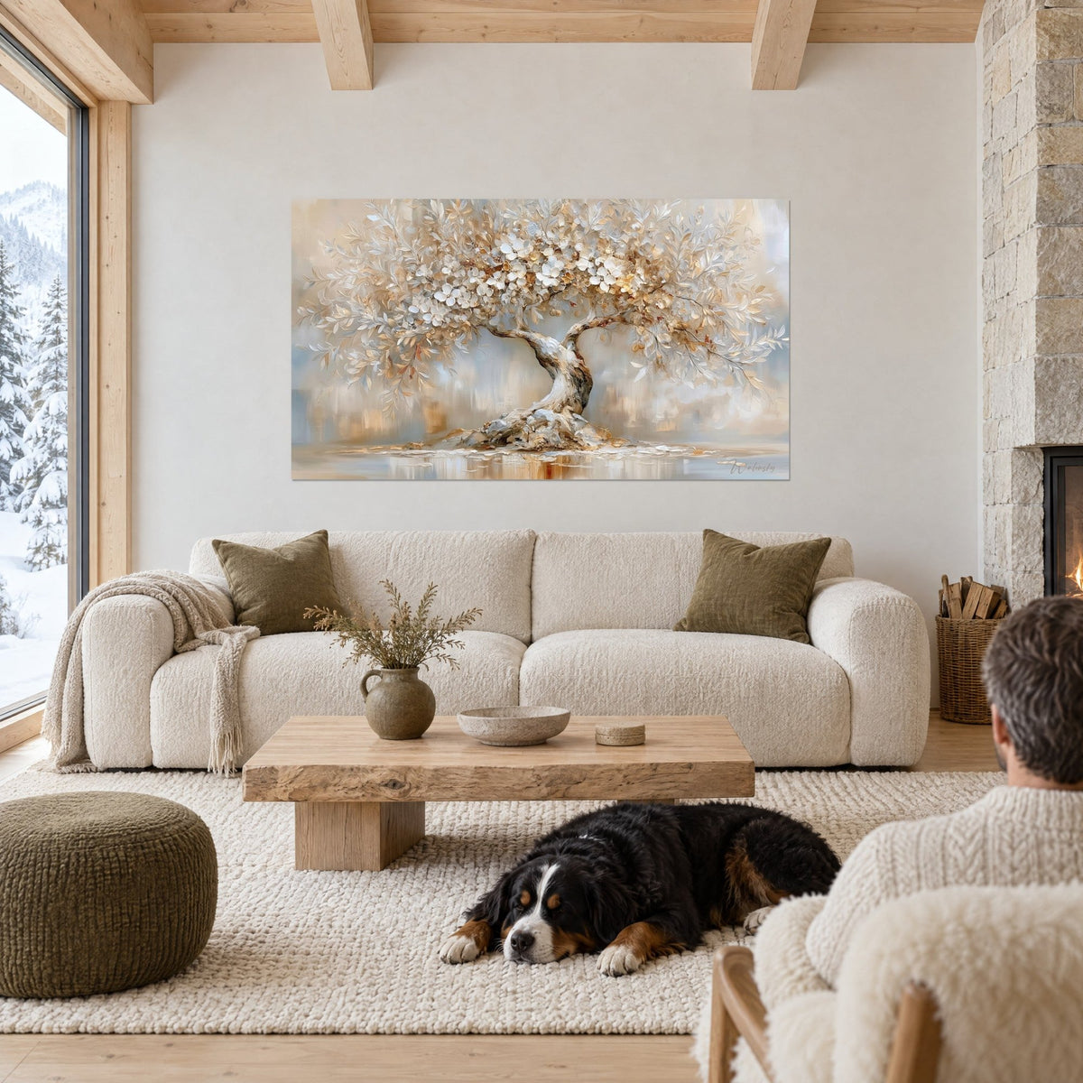 Gemälde Olivenbaum in Blüte mit elfenbeinfarbenen Blütenblättern und goldenen Reflexen, Paar von hinten und schwarzer Hund über einem Sofa in einem hellen Wohnzimmer