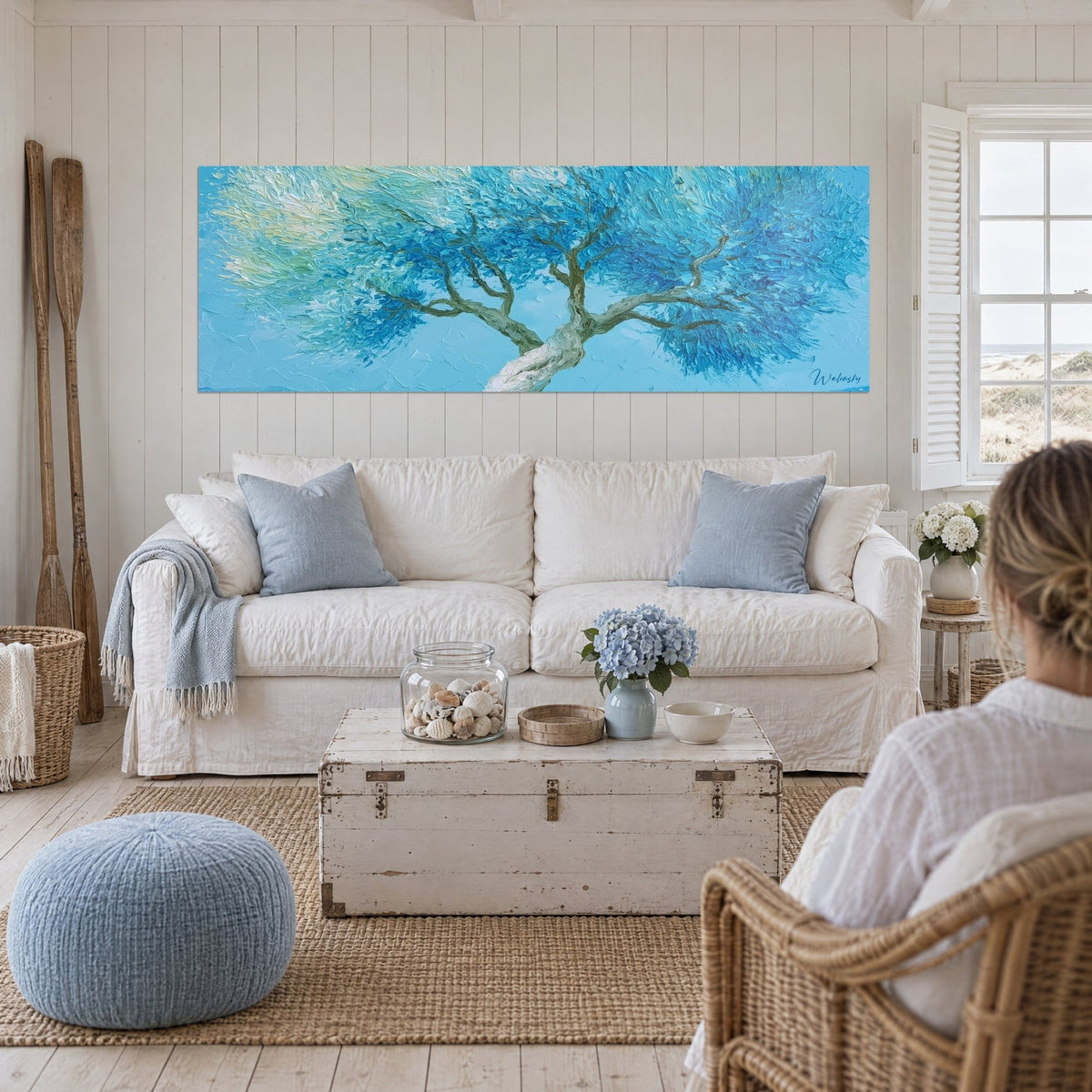 Gemälde Olivenbaum mit türkisblauem und cremeweißem Laub, verdrehter Stamm, über einem Sofa in einem lichtdurchfluteten Wohnzimmer
