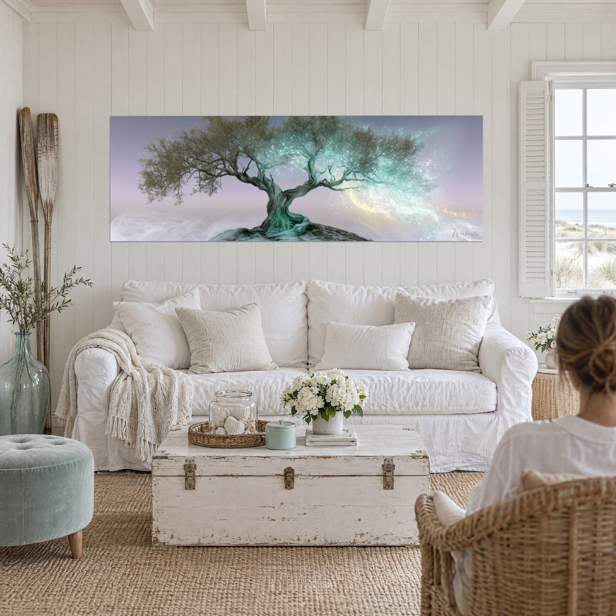 Wall art of a thousand-year-old olive tree with a twisted green trunk, turquoise and mauve mist, sparkling lights above a sofa in a bright living room