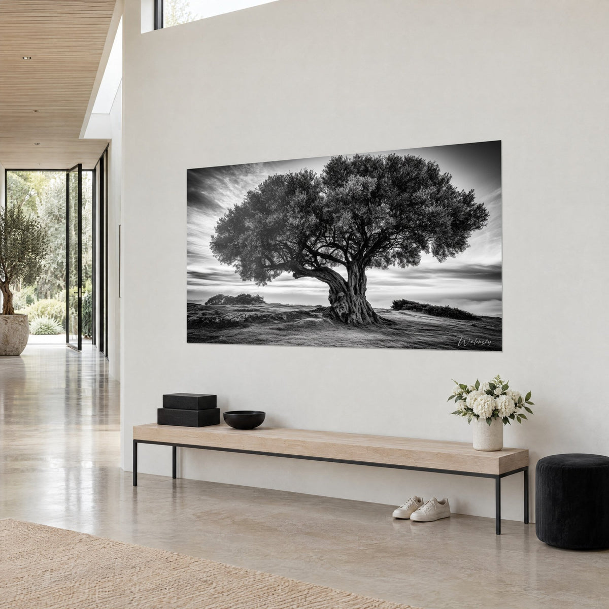 Wall art century-old tree with a round canopy and twisted trunk, white and charcoal sky, seen at three-quarter view on a cream wall