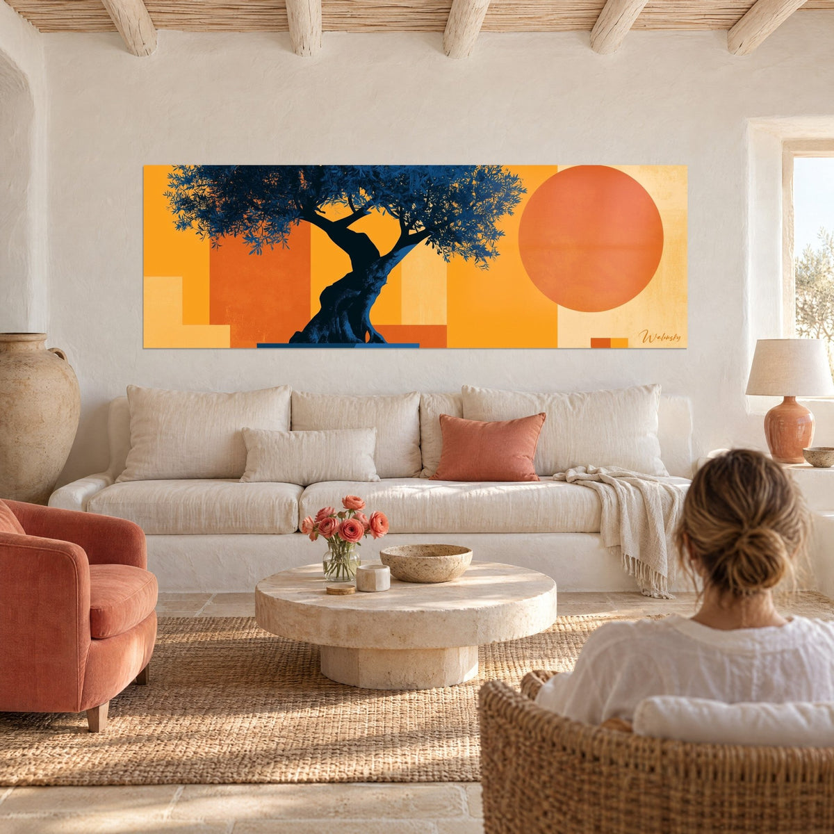 Gemälde knorrige Olivenbaum mit marineblauem Laub vor einer orangefarbenen Scheibe, eine Frau von hinten, über einem Sofa in einem hellen Wohnzimmer. Walensky