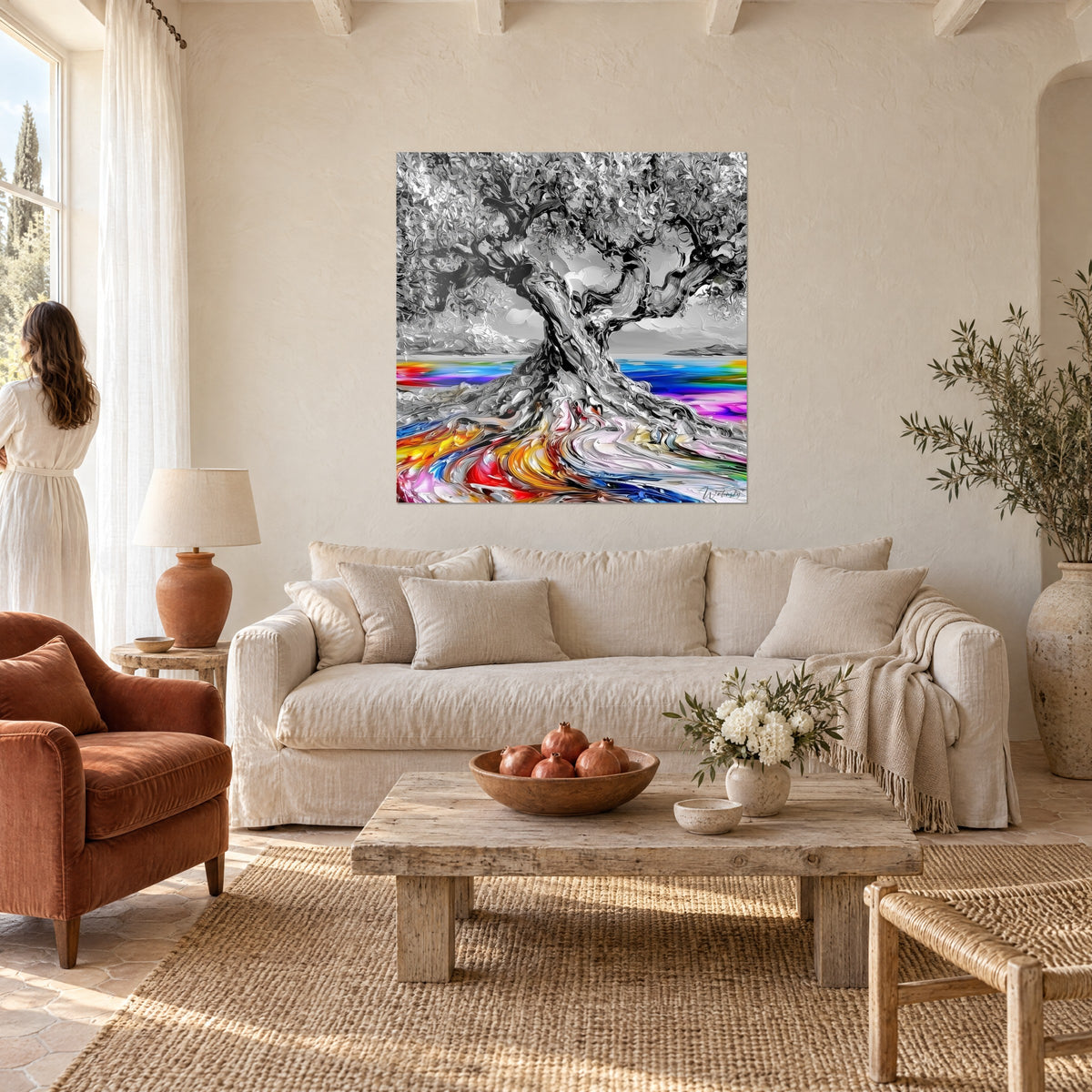 Schilderij knoestige olijfboom in zwart-wit, regenboogwortels in rood en oranje, boven een bank in een lichte woonkamer