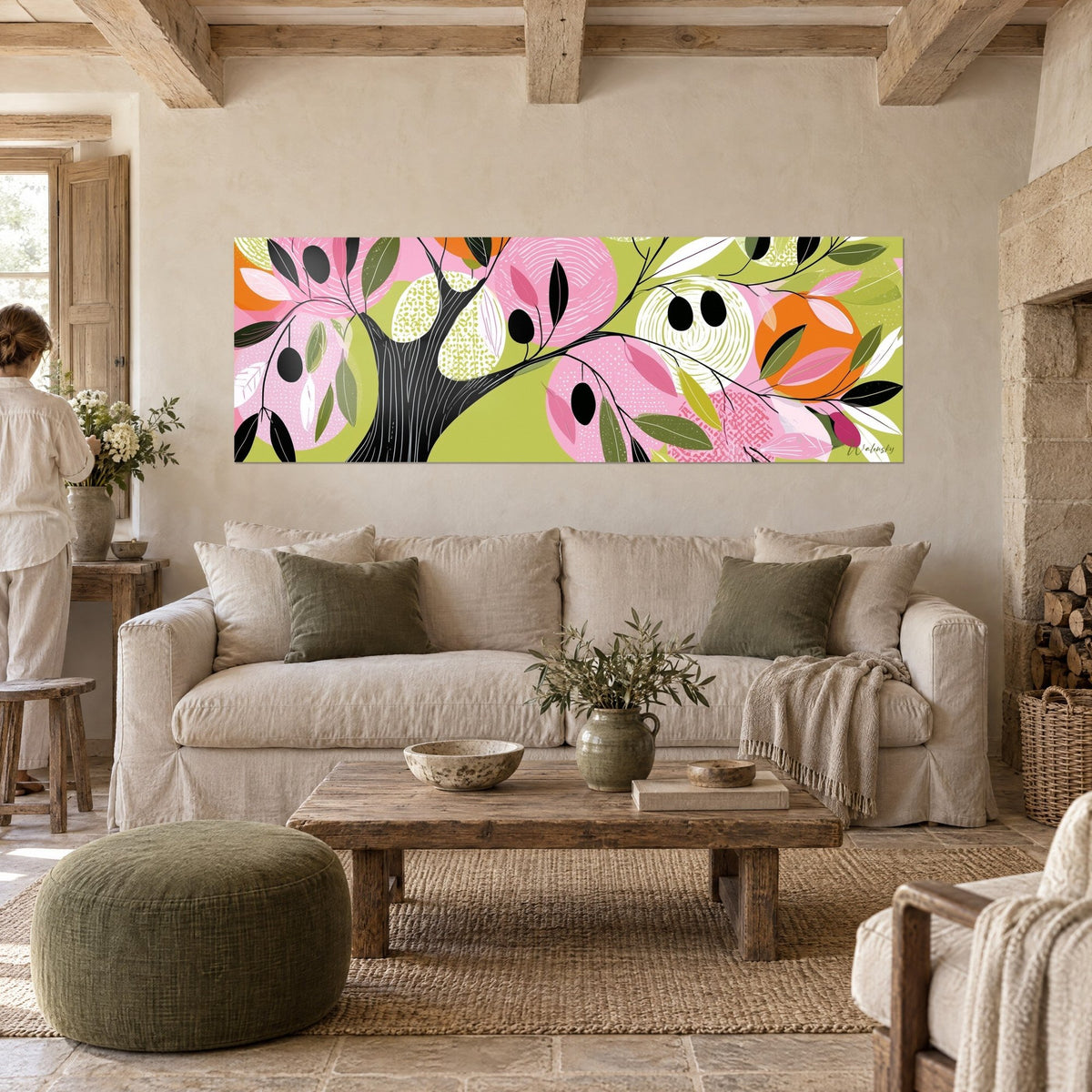 Wall art stylized olive tree with black olives, pink and green leaves on anise background, a woman seen from behind, above a sofa in a bright living room