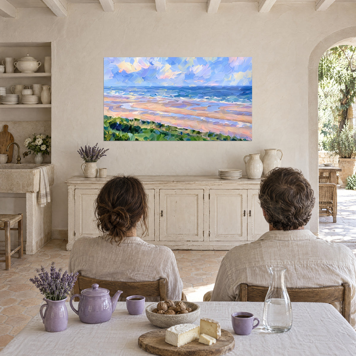 Tableau bord de mer impressionniste, grève rose saumon, flots outremer et nuages pastel, face à un couple attablé dans le mas