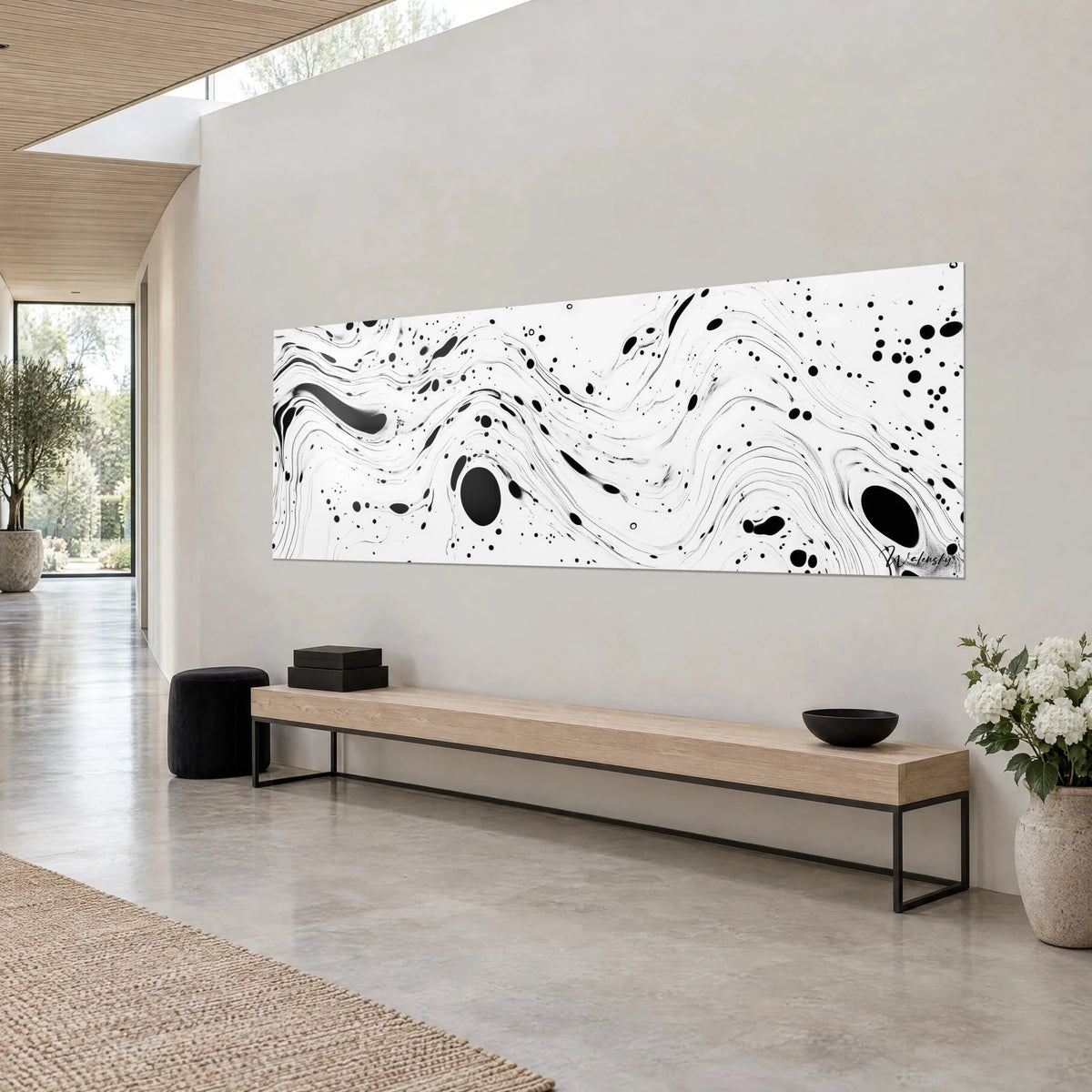 Wall art with rippling black and white marbling, large round ink drops and fine swirls, beige wall, light wood bench